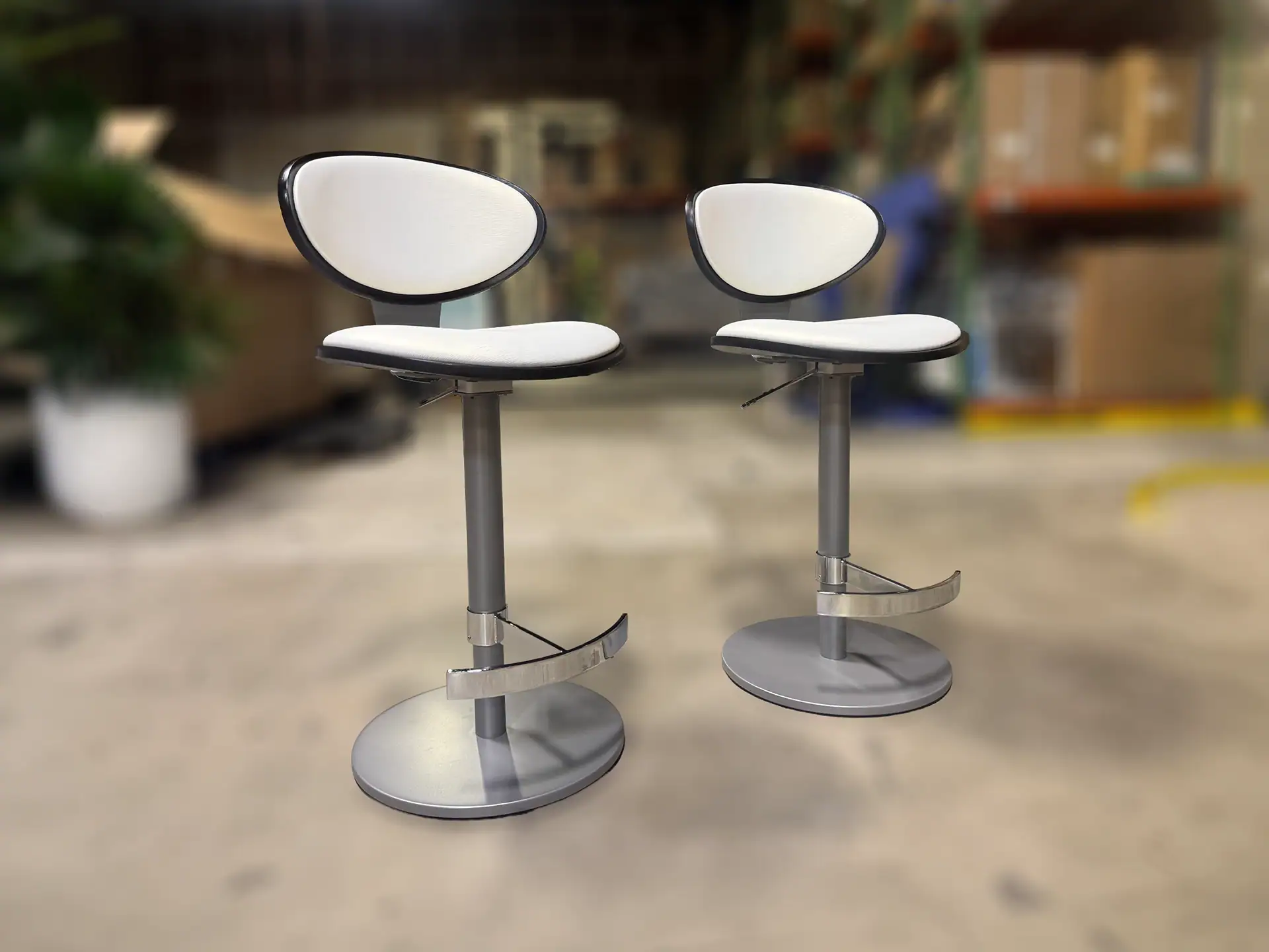 Sklar Furnishings Elite Vera hydraulic bar stools with white seats and black trim.