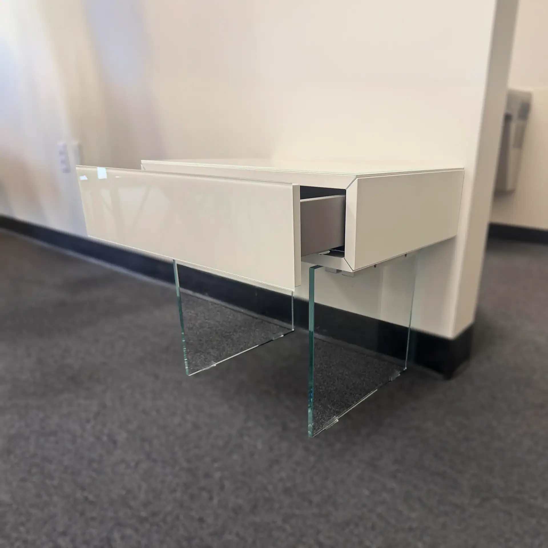 Sklar Furnishings Lago 36e8 nightstand with glass legs in a modern room.
