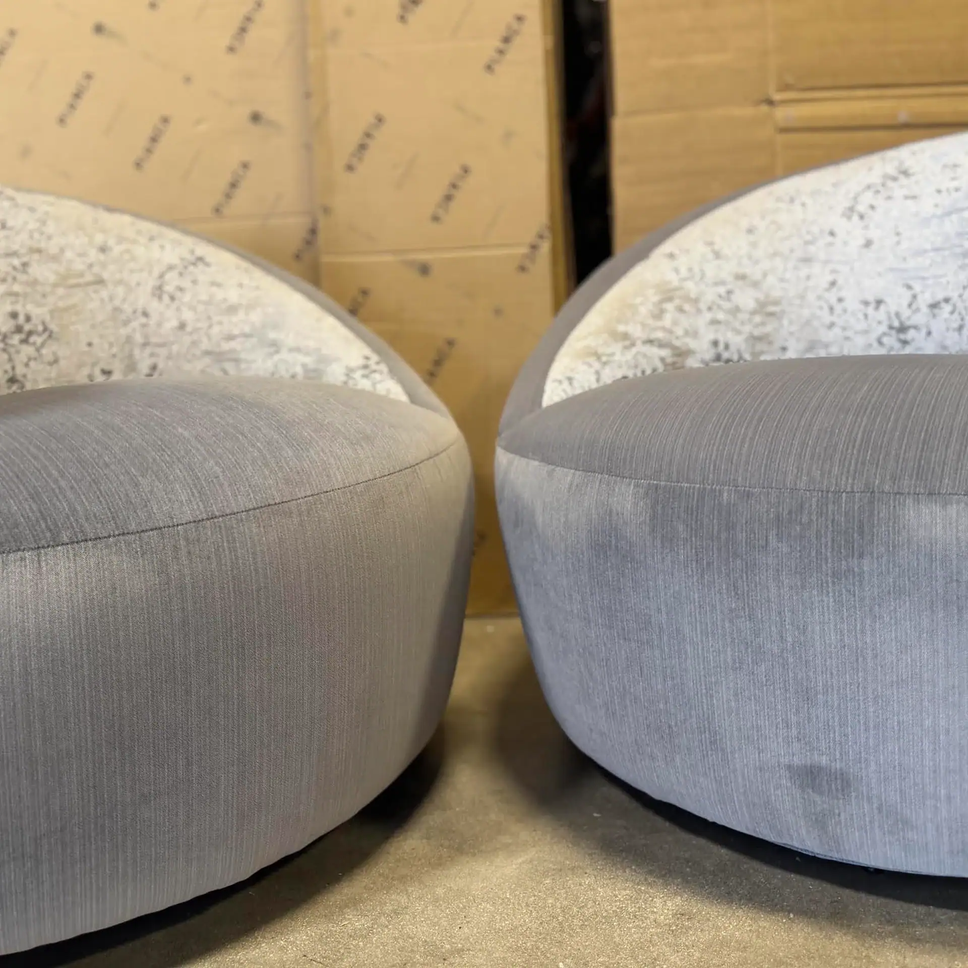 Lazar Scroll Swivel Chairs in light grey fabric in a room setting.