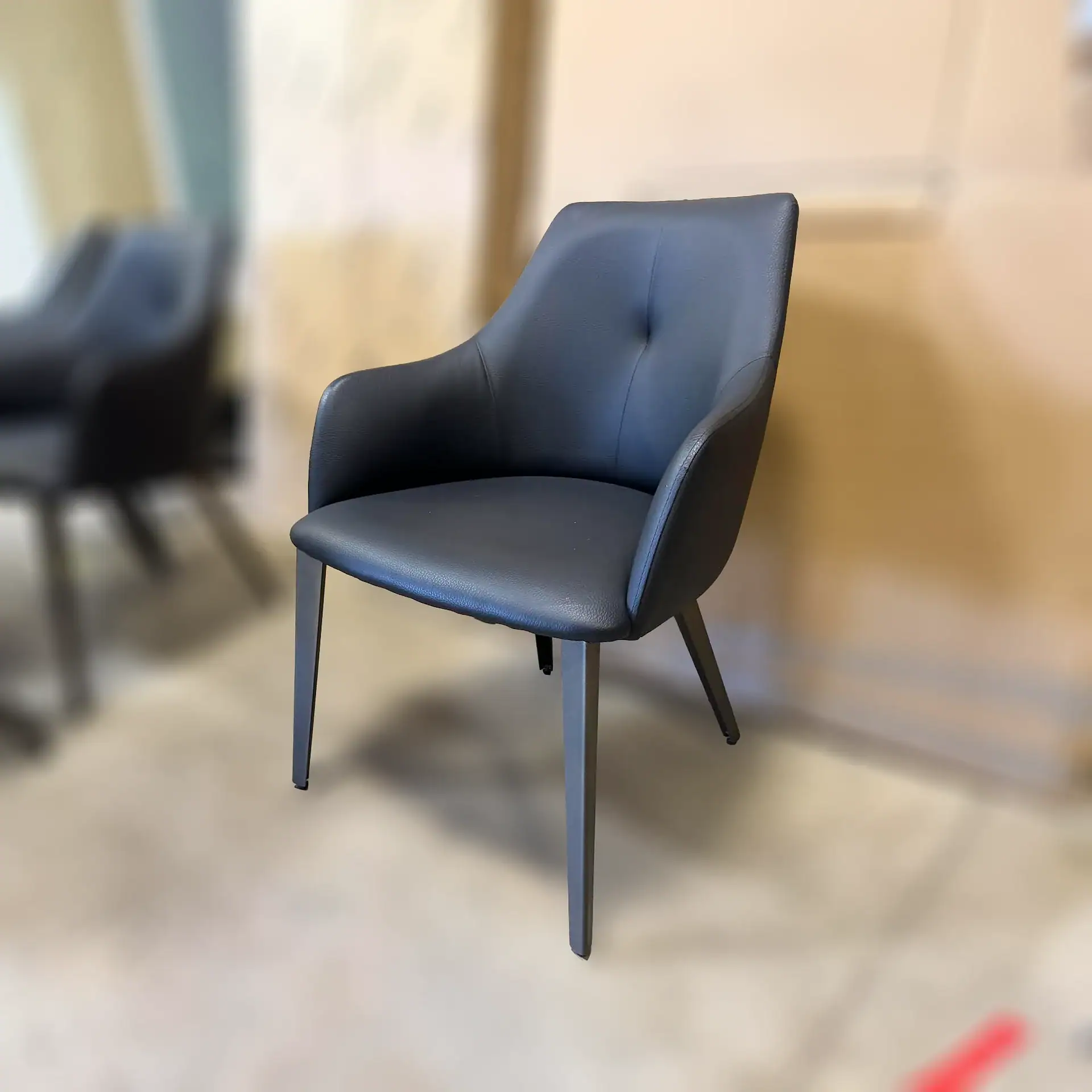 Nuevo Renee dining chair with black upholstery and wooden legs.