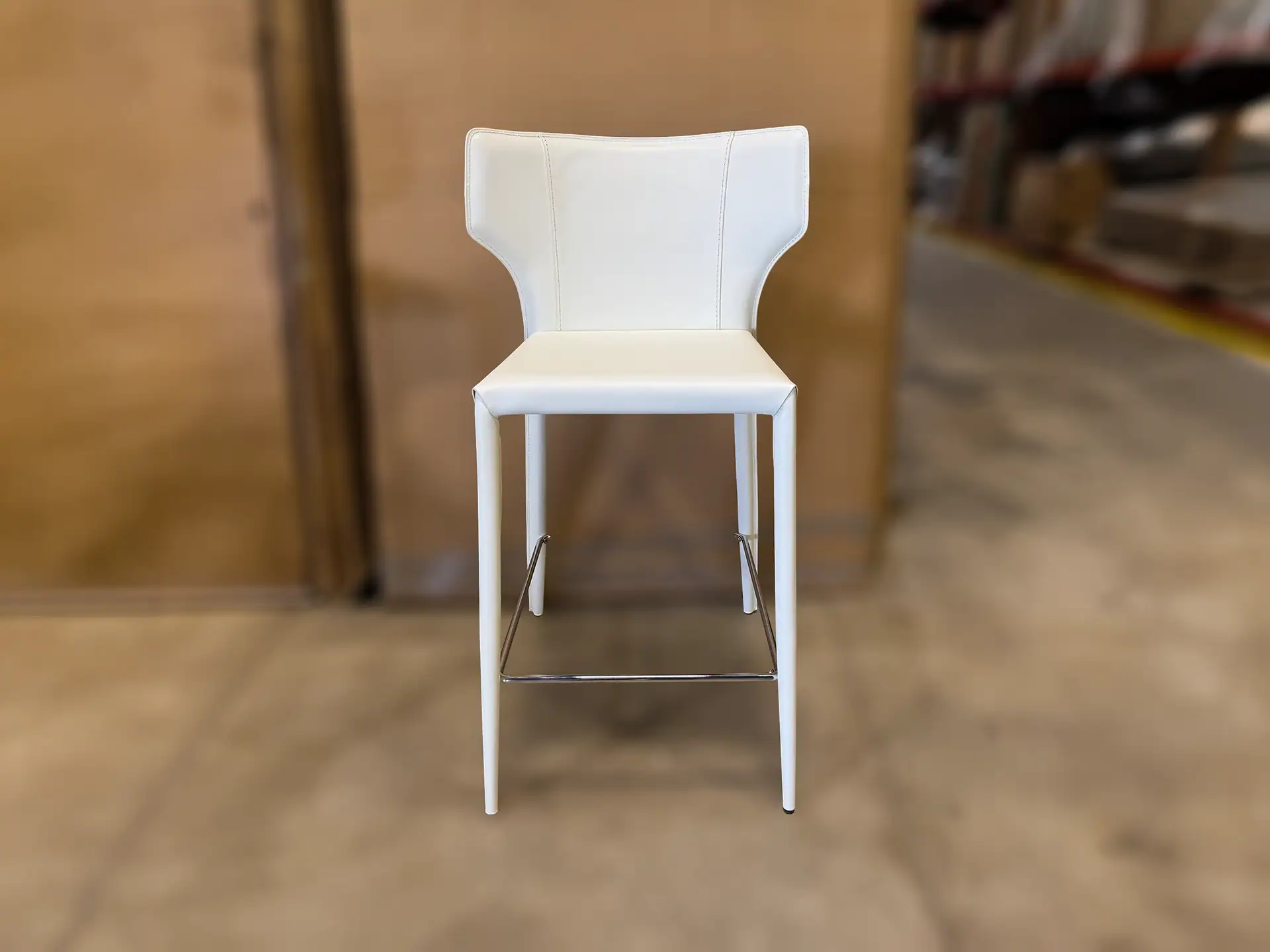 Sklar Furnishings Nuevo Wayne bar stool with white upholstery and metal footrest.
