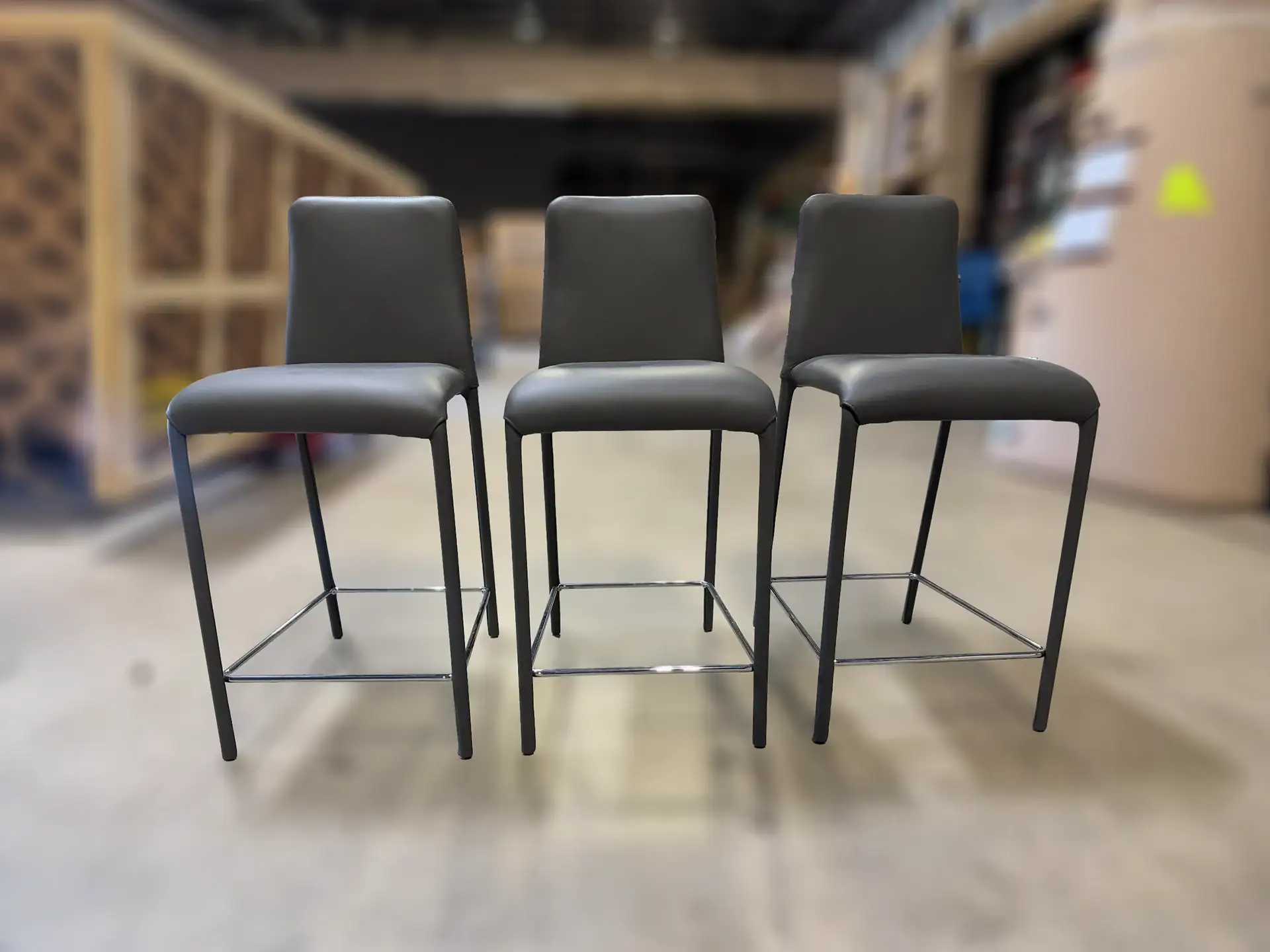 Peressini Casa Swing fixed counter stools three in a row in a warehouse.