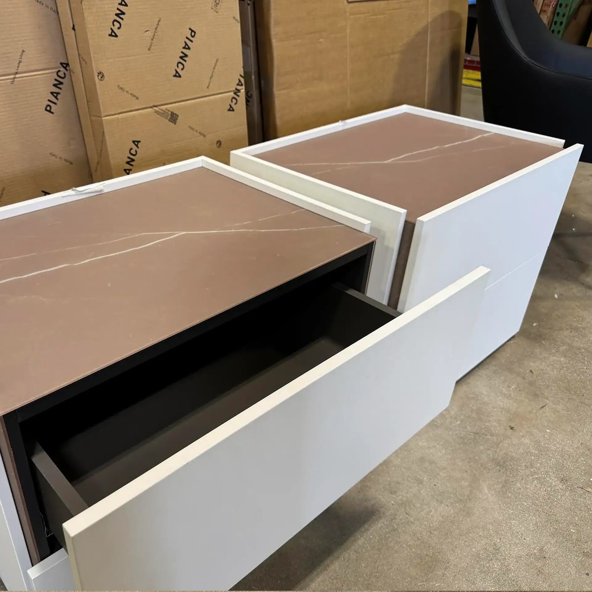 Pianca Atlante nightstands with open drawers in a warehouse setting.
