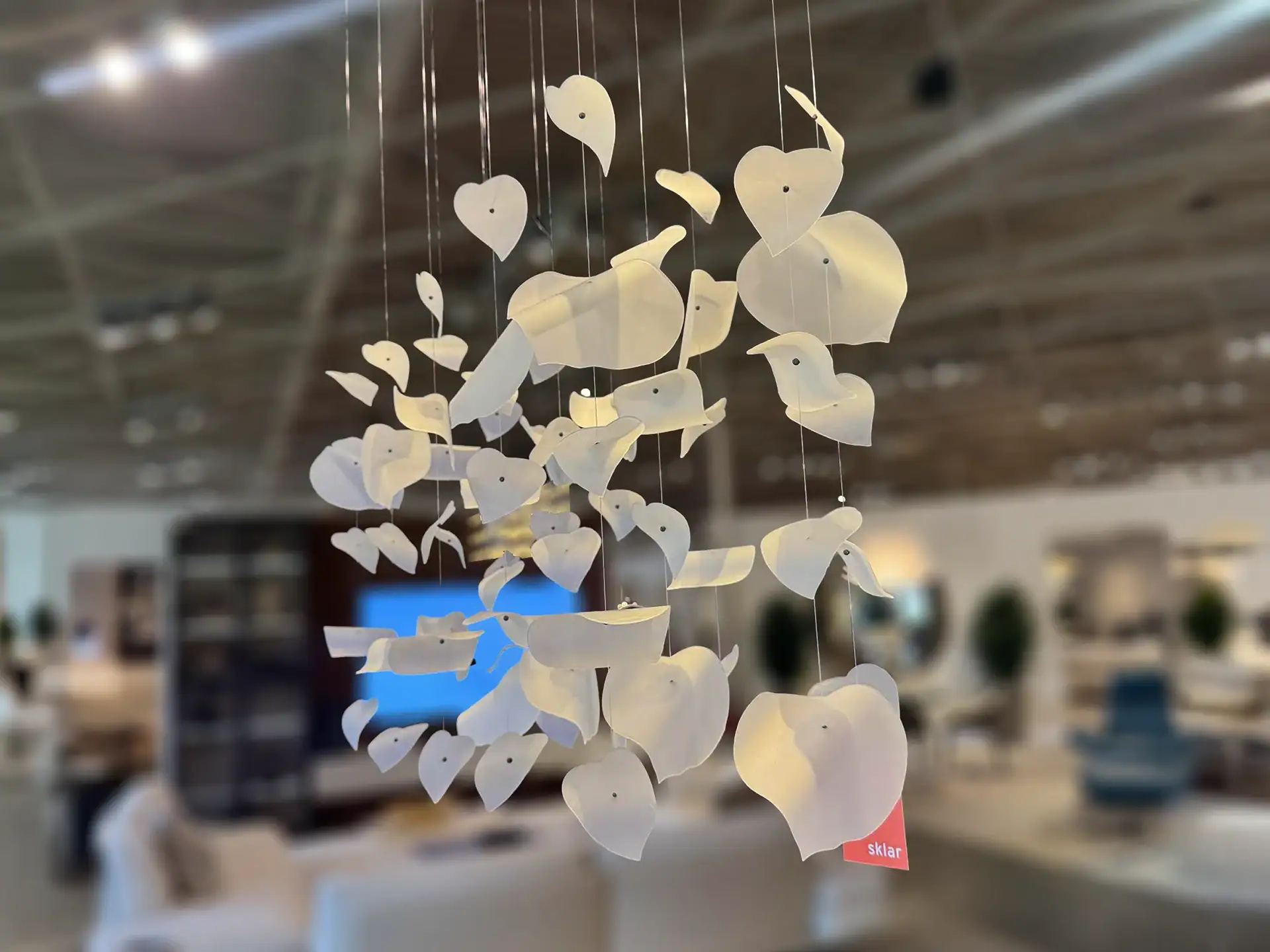 Sklar Furnishings Reflex Leaf LED chandelier hanging in a showroom.