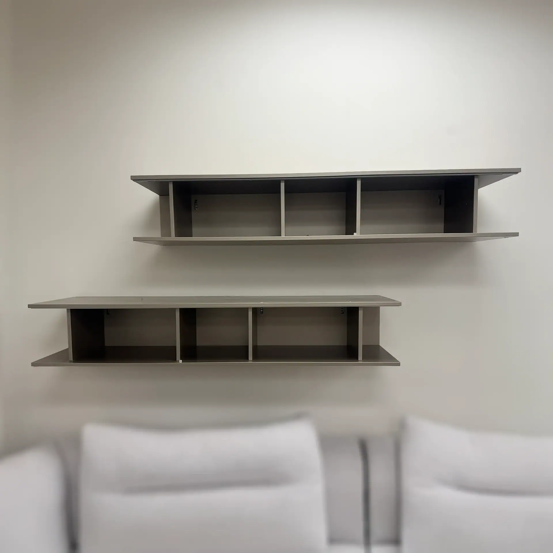 San Giacomo Alias hanging bookcase with multiple shelves on a plain wall.