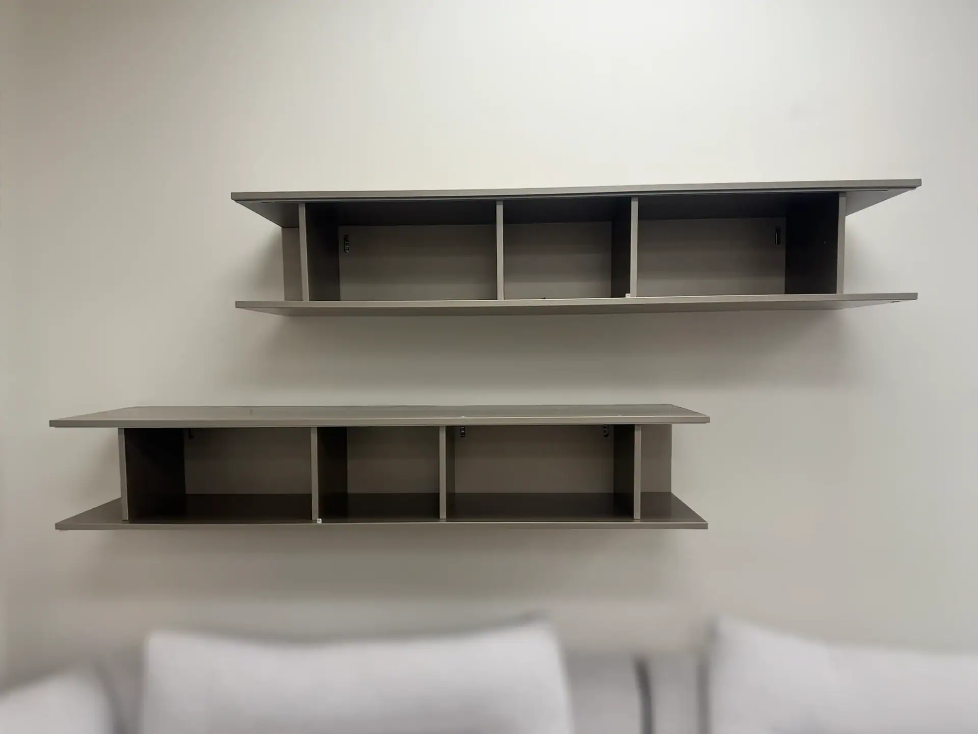 Sklar Furnishings San Giacomo Alias hanging bookcase with two shelves on a plain wall.