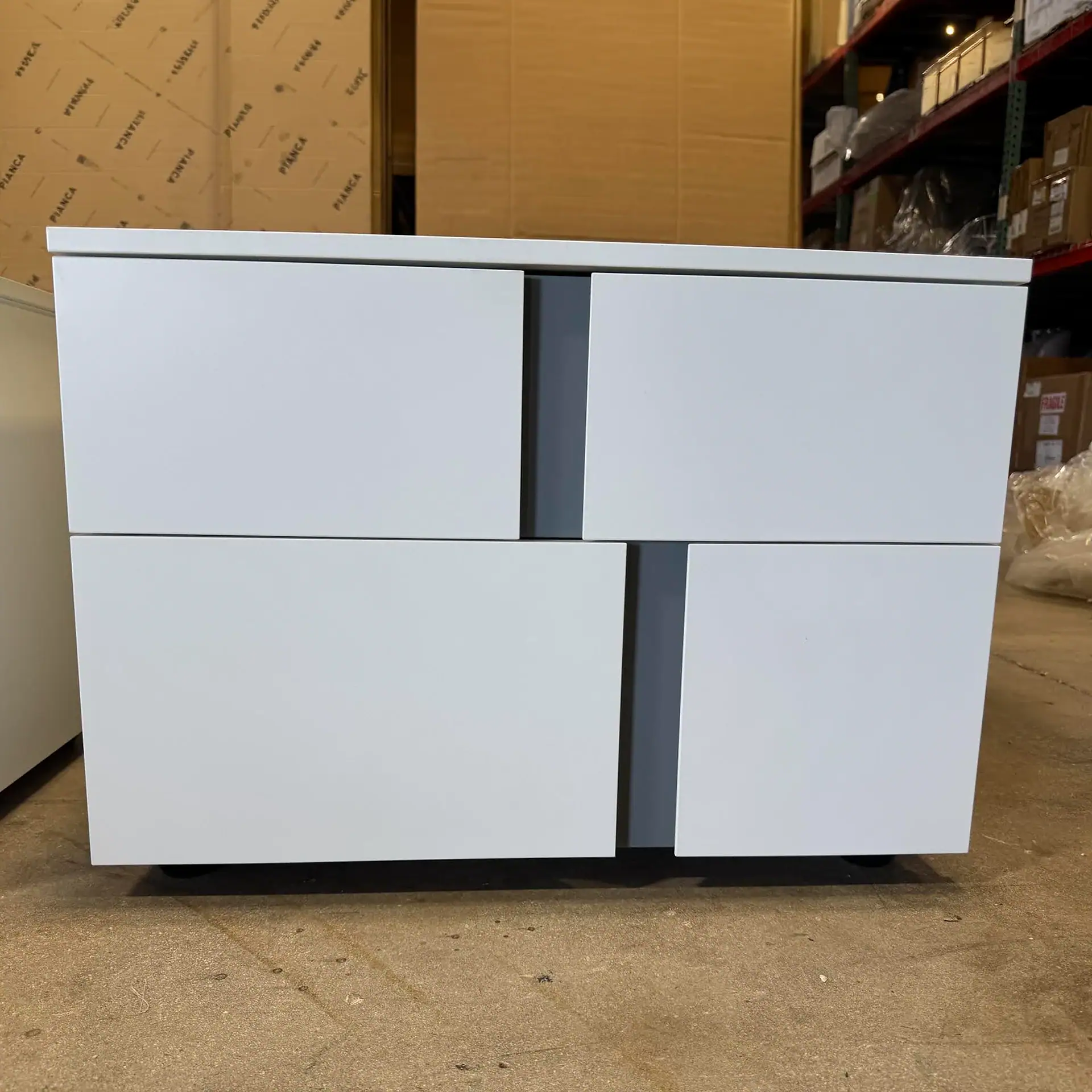Sklar Furnishings nightstand with two drawers in a warehouse setting.