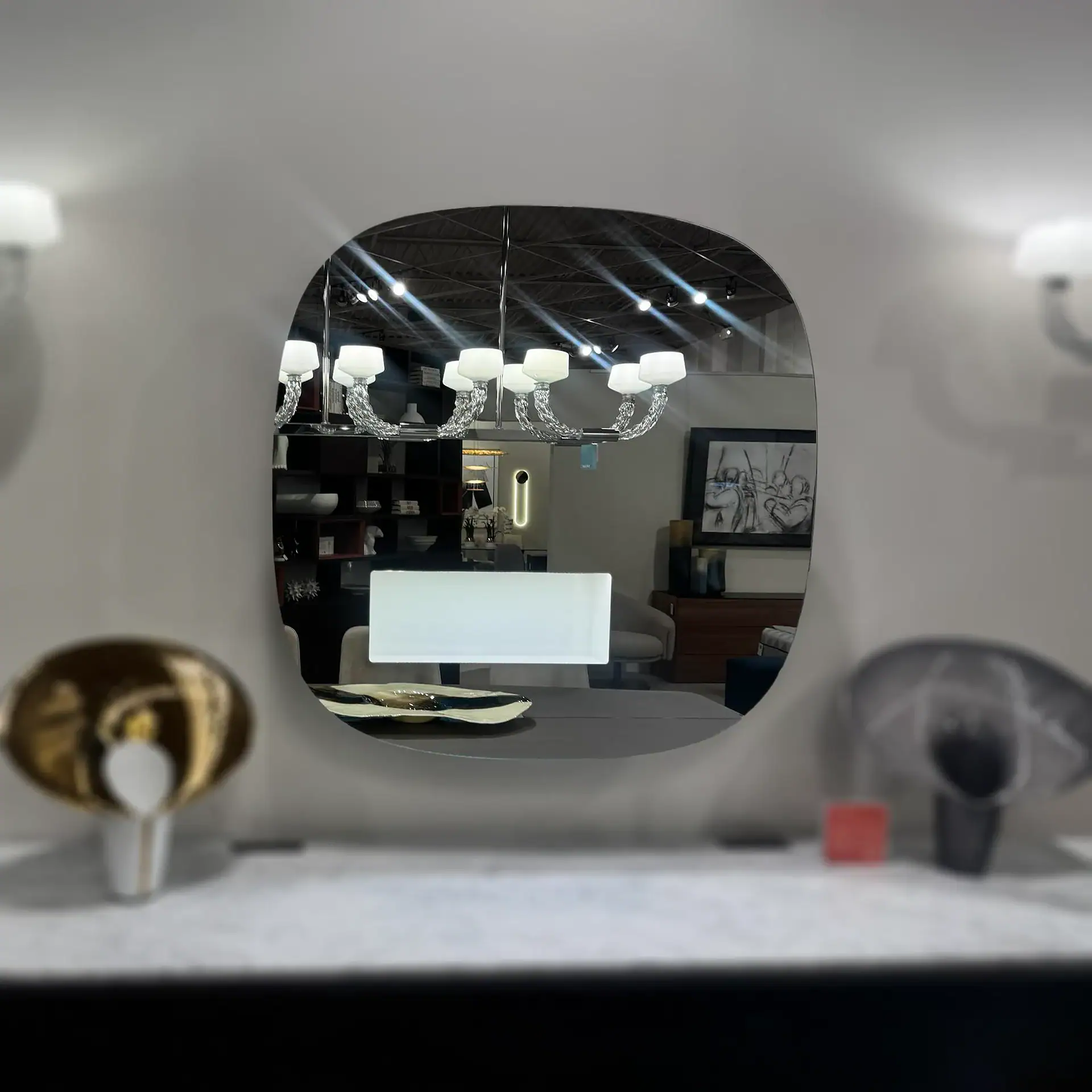 Reflective LED mirror with rounded edges in a modern room setting.