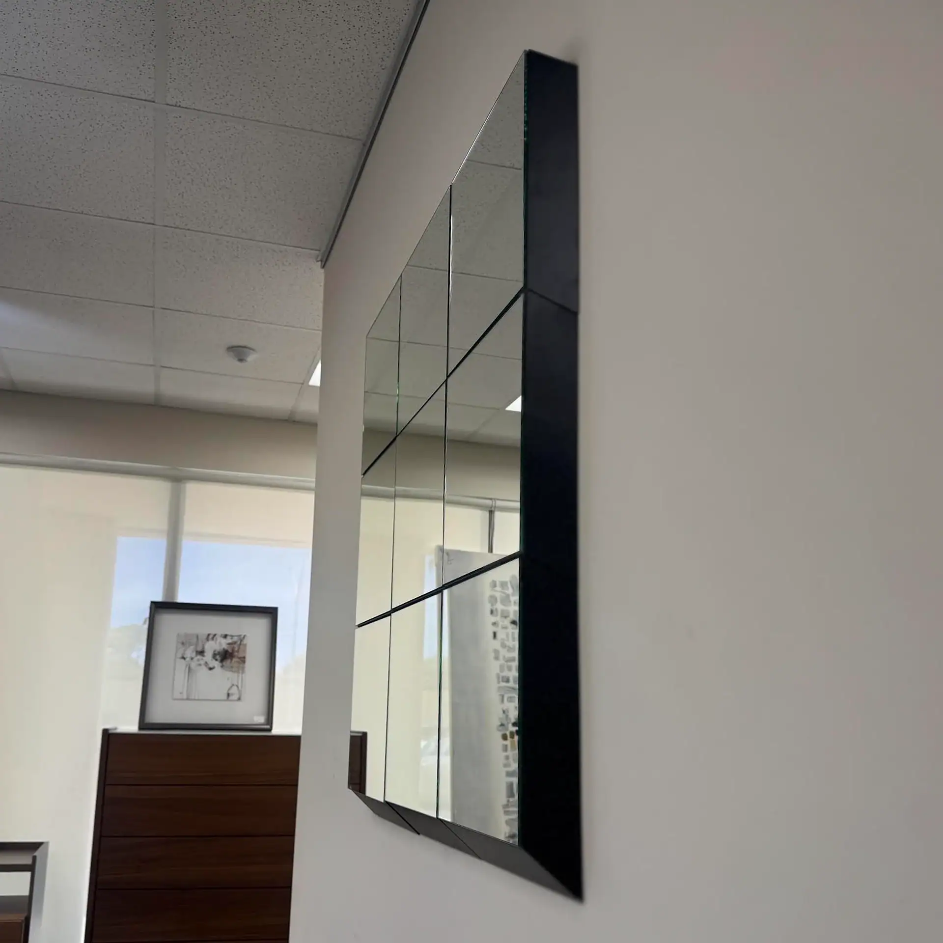 Tonelli Guidoriccio modular mirror tile in a modern room setting.