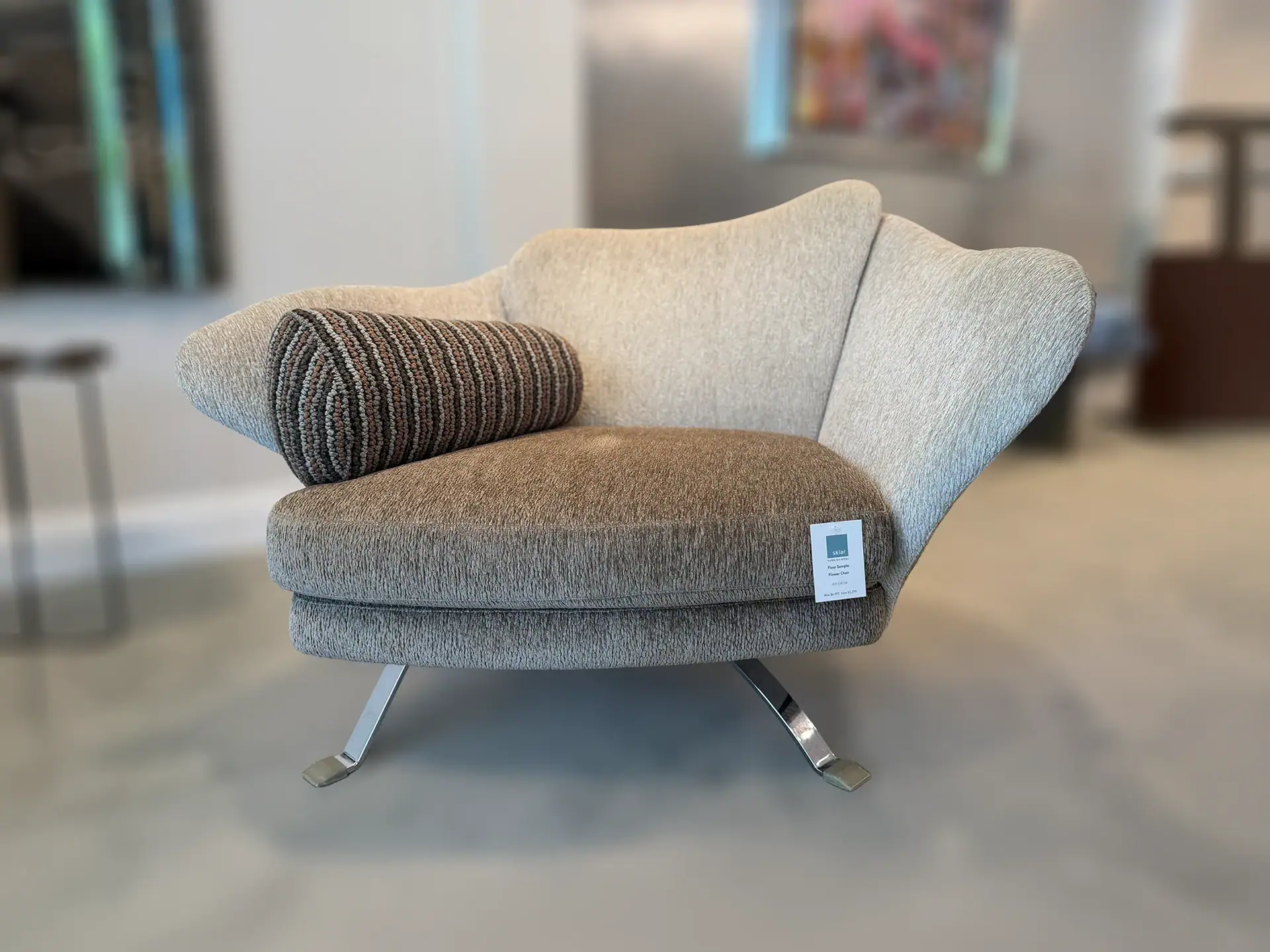Sklar Furnishings Flower Armchair with striped pillow in a showroom.
