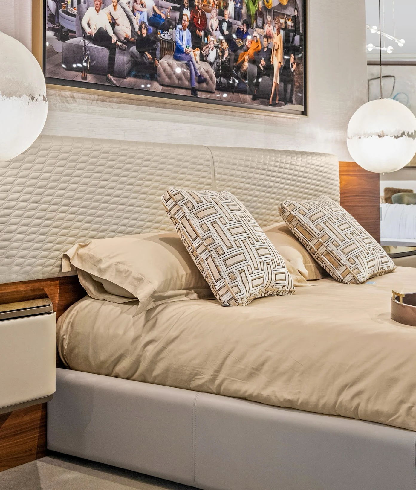 Modern bed with textured beige headboard and geometric pillows in a contemporary bedroom.