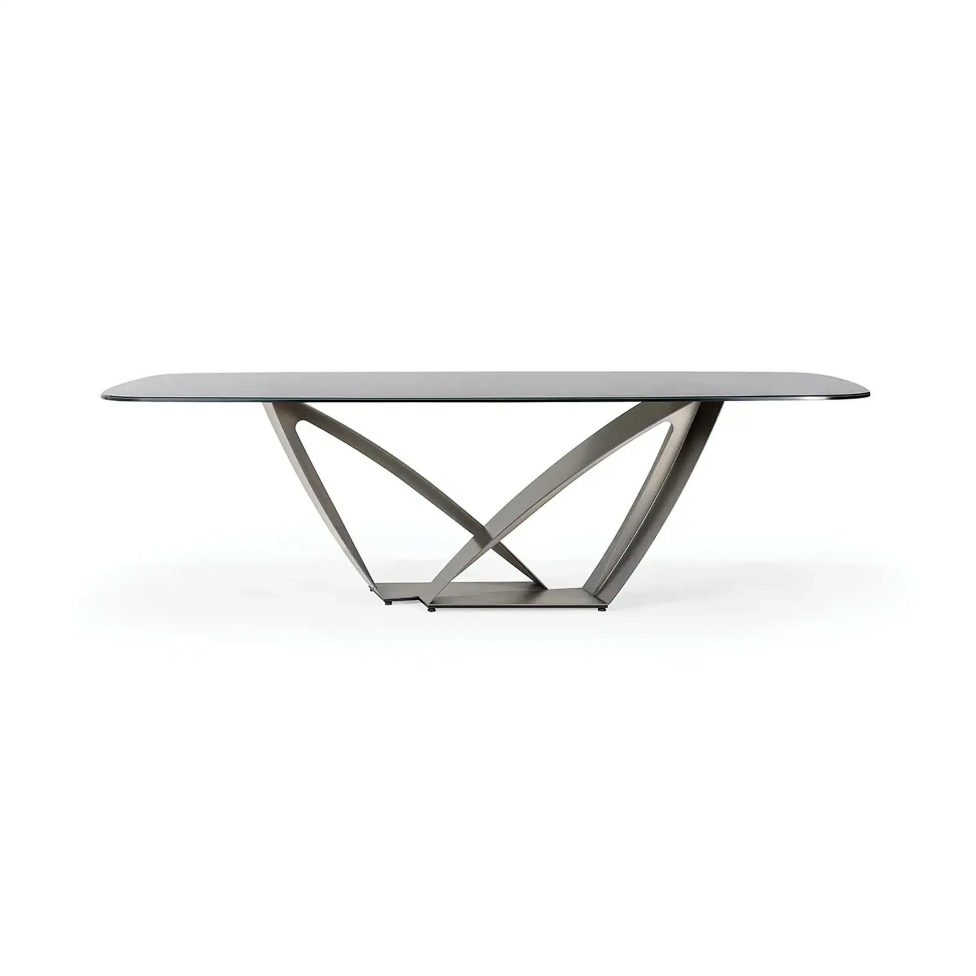 A modern dining table with a rectangular glass top and an intricate, sculptural dark metal base on a white background.