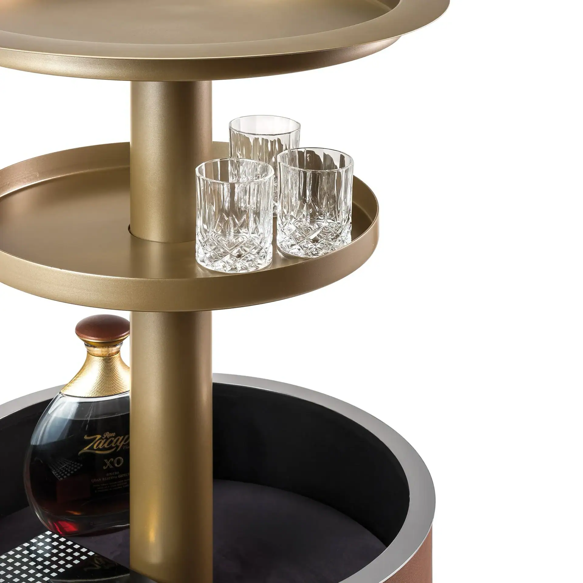Sklar Furnishings bar cart with glasses and bottle on a gold and black stand.