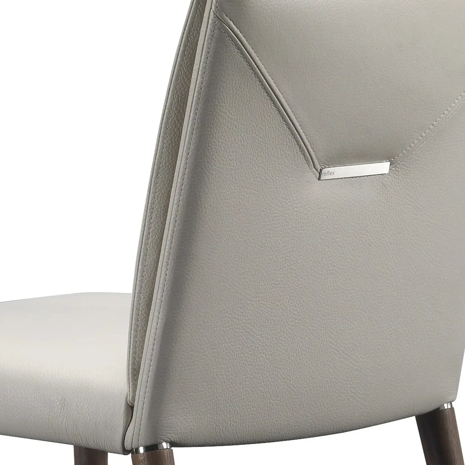 Close-up of a light gray textured leather chair back with diagonal stitching and a silver 'reflex' tag. Part of the seat and dark wooden legs are visible.