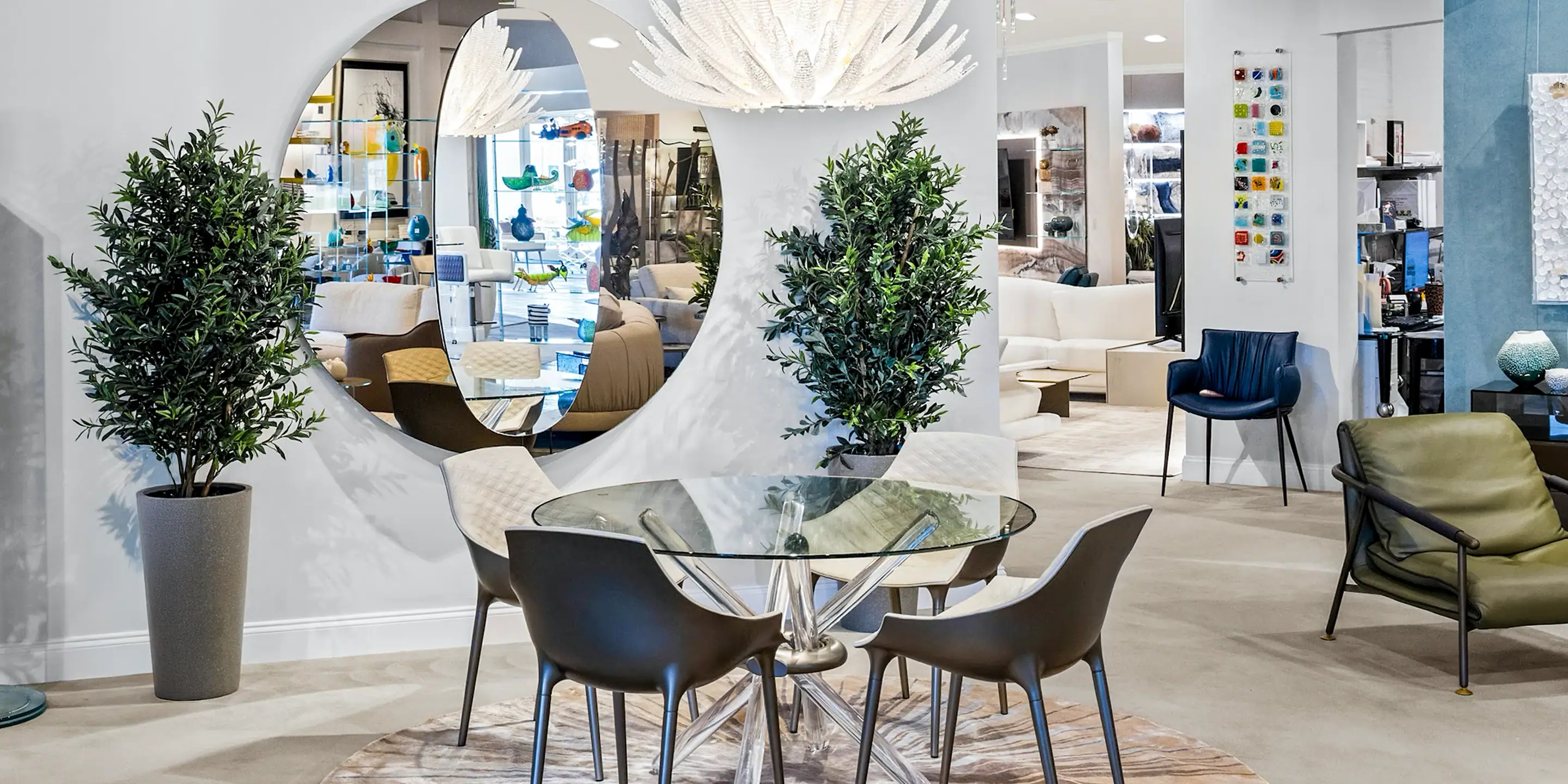 showroom-vignette-jun-26-dining-room Contemporary living room with green potted plants and stylish furniture.