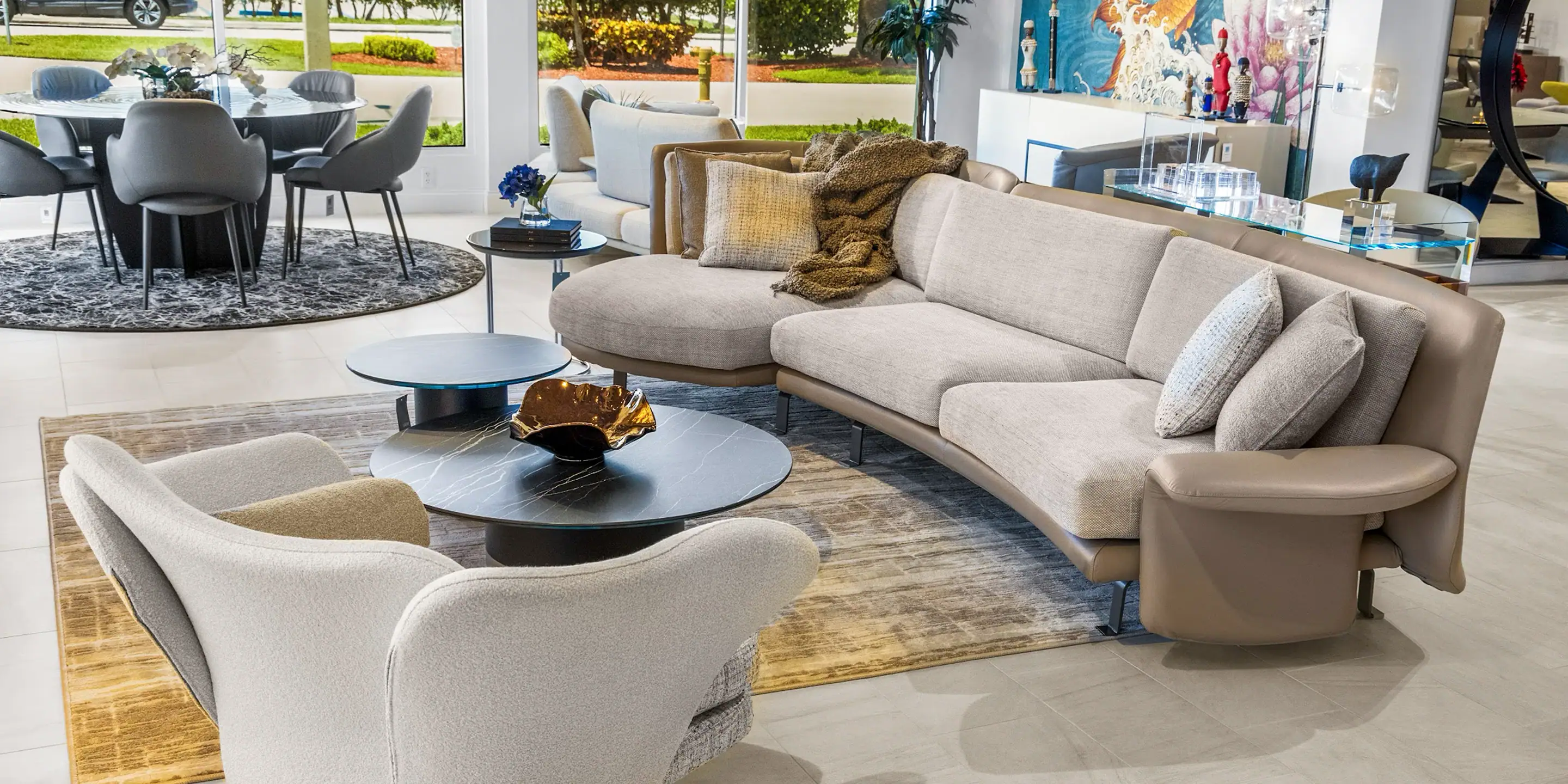 showroom-vignette-jun-26-living-room-3 Sklar Furnishings sofa in a modern living room with large windows and artwork.