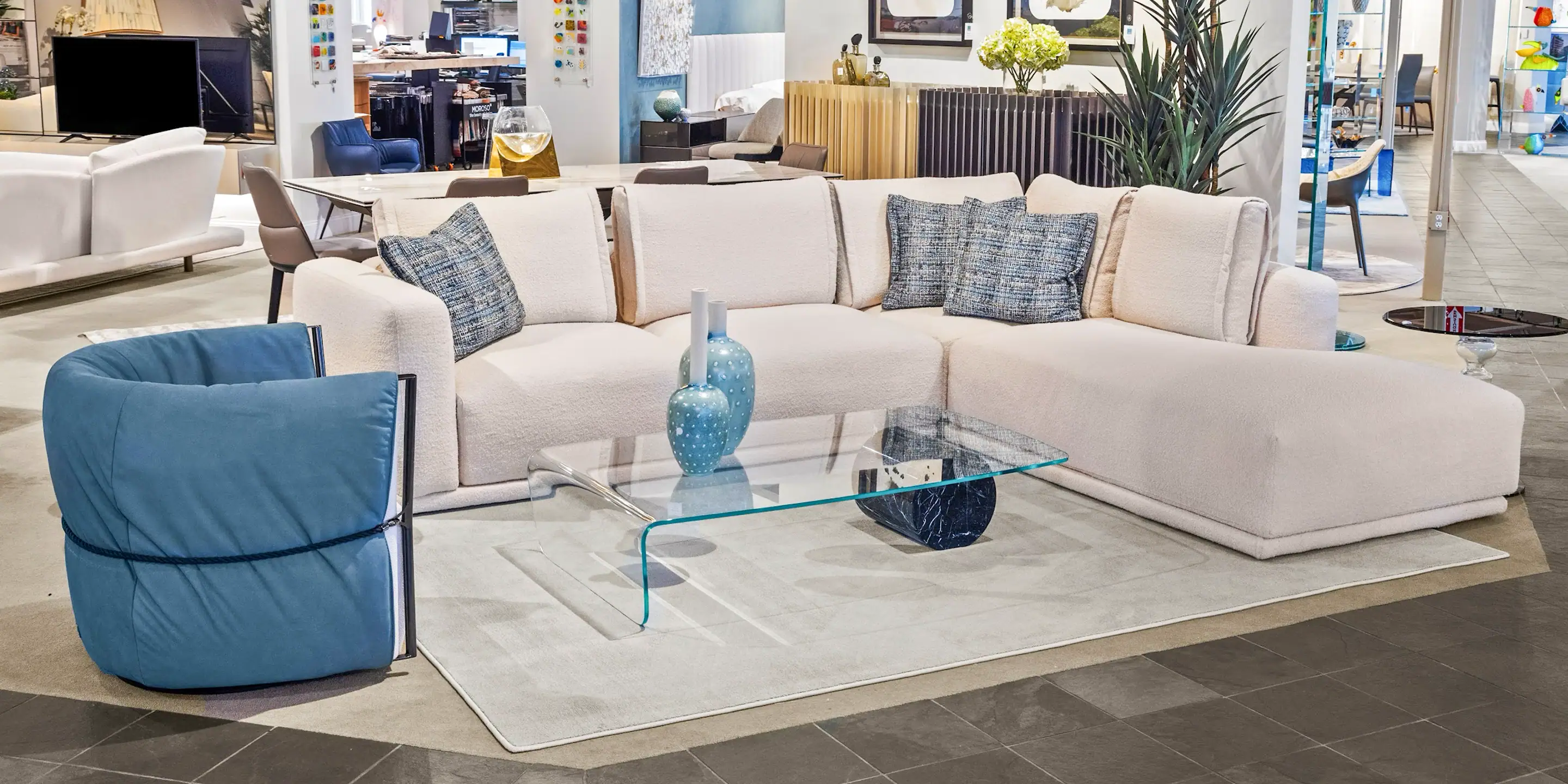Modern L-Shaped Sofa by Sklar Furnishings Sklar Furnishings L-shaped sofa with blue accent pillow in a showroom.