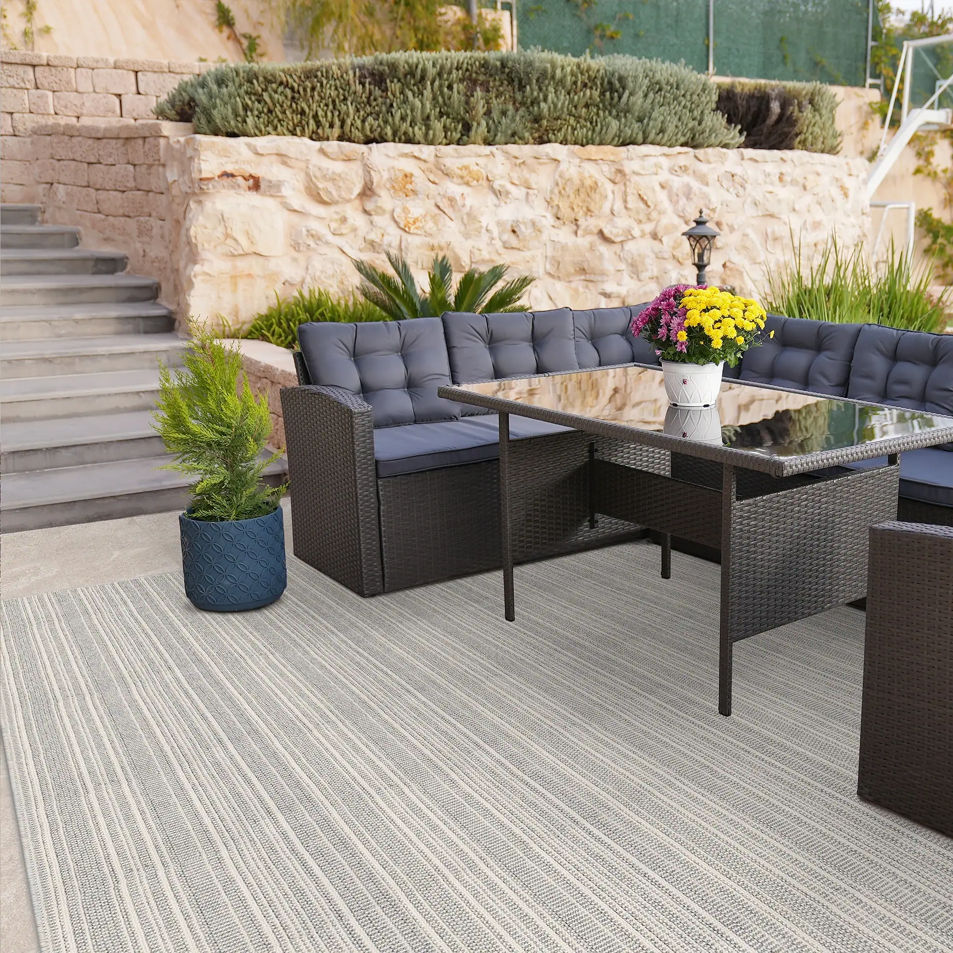 Waveside indoor outdoor area rug with outdoor furniture and plants.