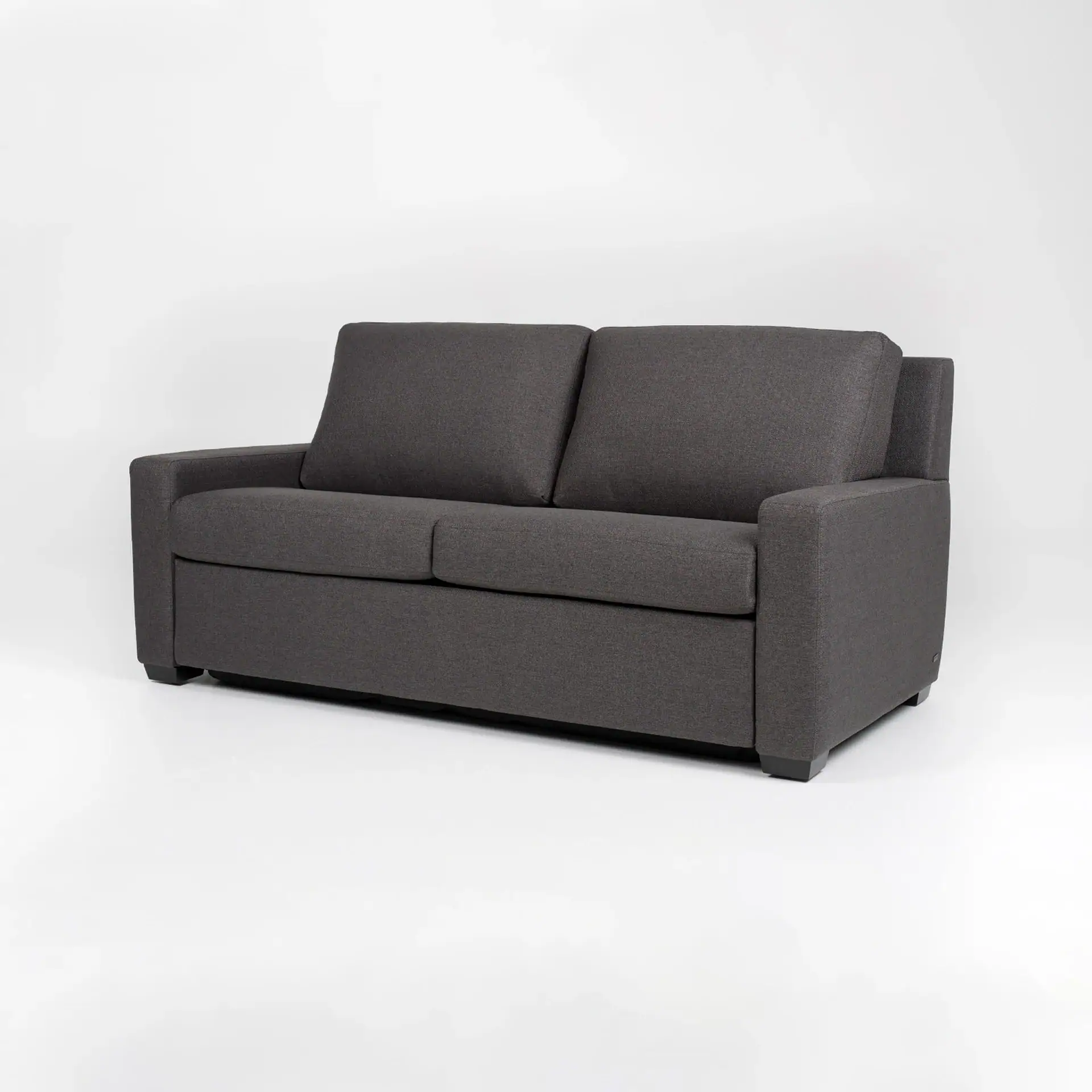 A dark gray two-seater sofa with square arms and cushions, set against a white background.