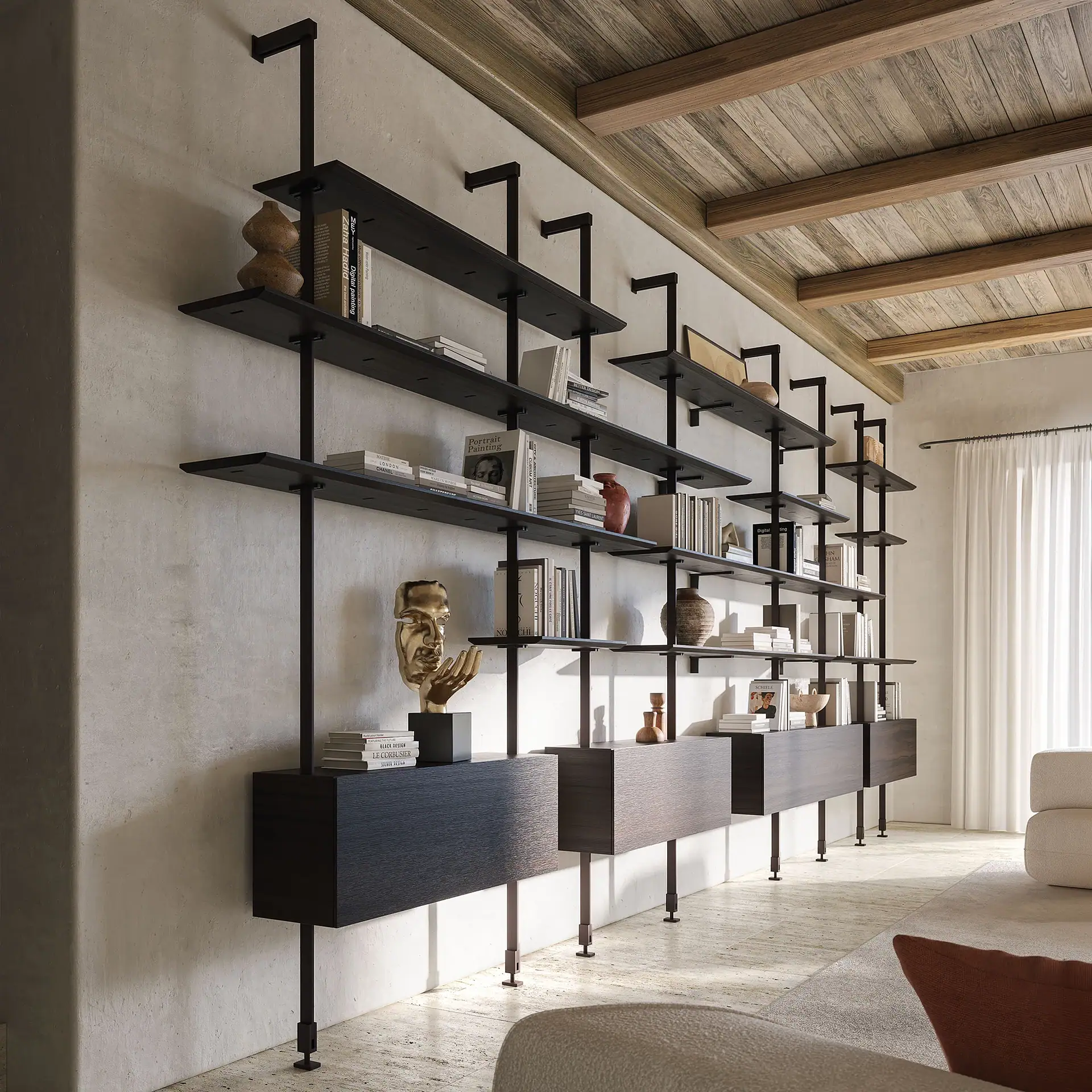 A modern black modular shelving unit with dark wooden shelves and integrated drawers, filled with books and decorative objects, against a light textured wall in a room with a wooden beamed ceiling.