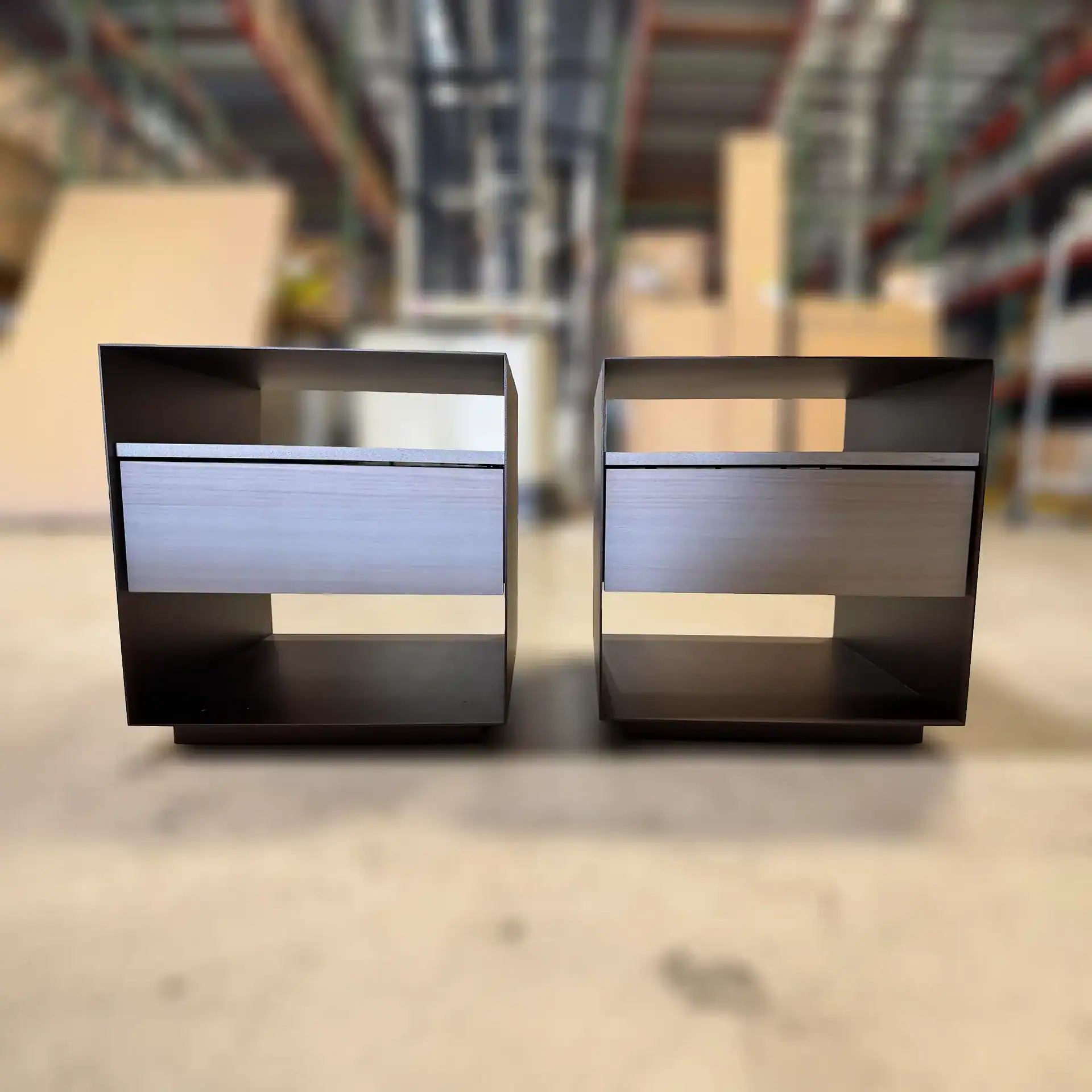 Two Sklar Furnishings nightstands with drawers in a warehouse setting.