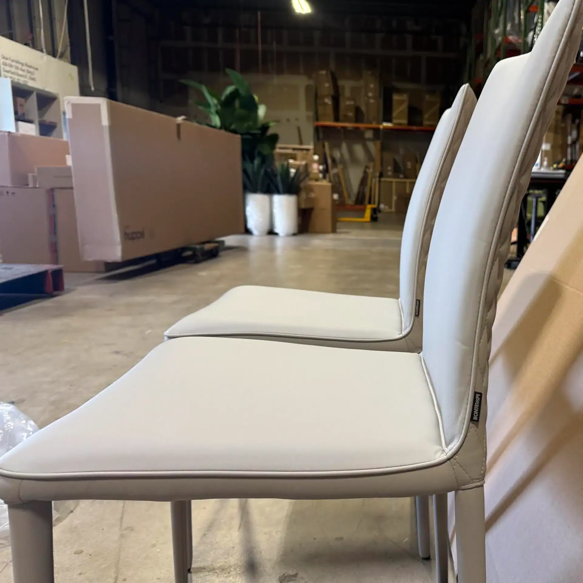 Two Shefi Quilted Dining Chairs in a warehouse setting.