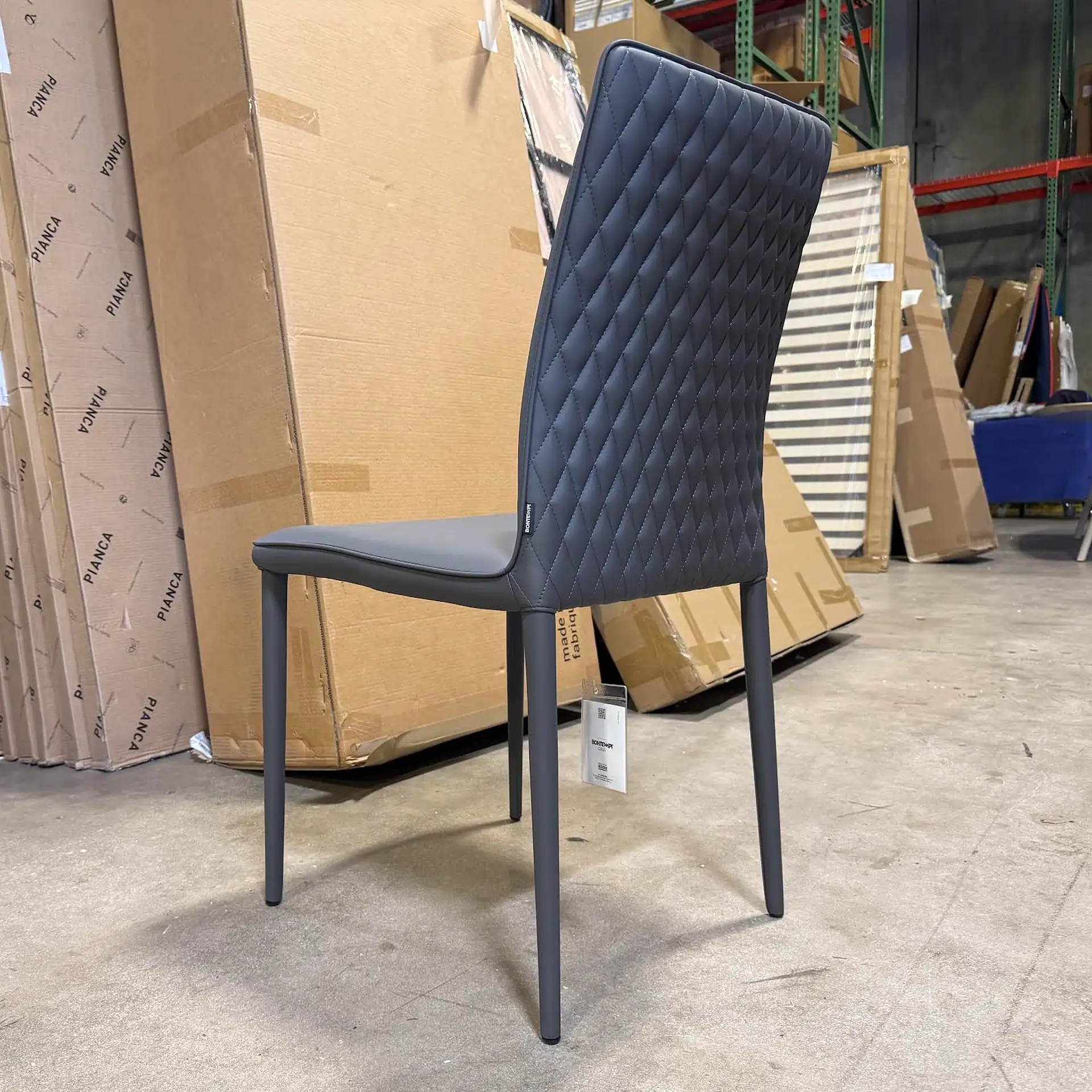 Bontempi Shefi Flex dining chair with quilted backrest in a warehouse setting.