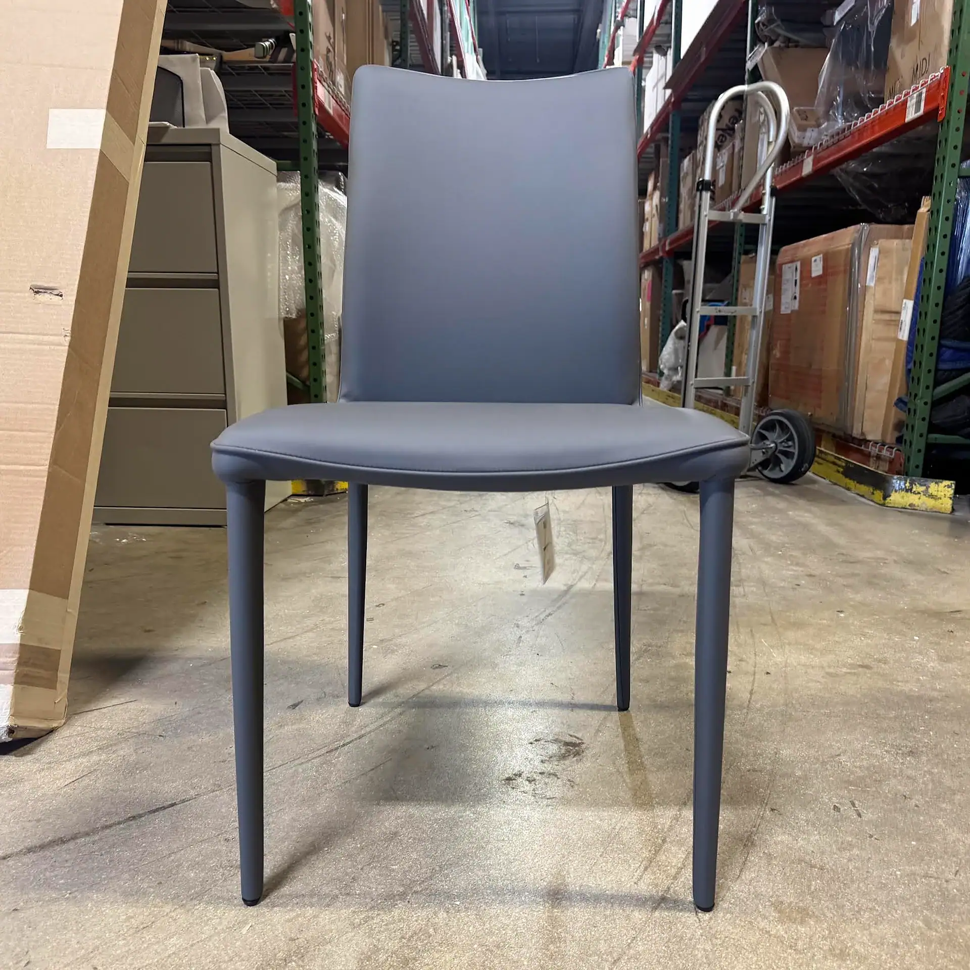 Bontempi Shefi Flex dining chair with grey upholstery in warehouse setting.