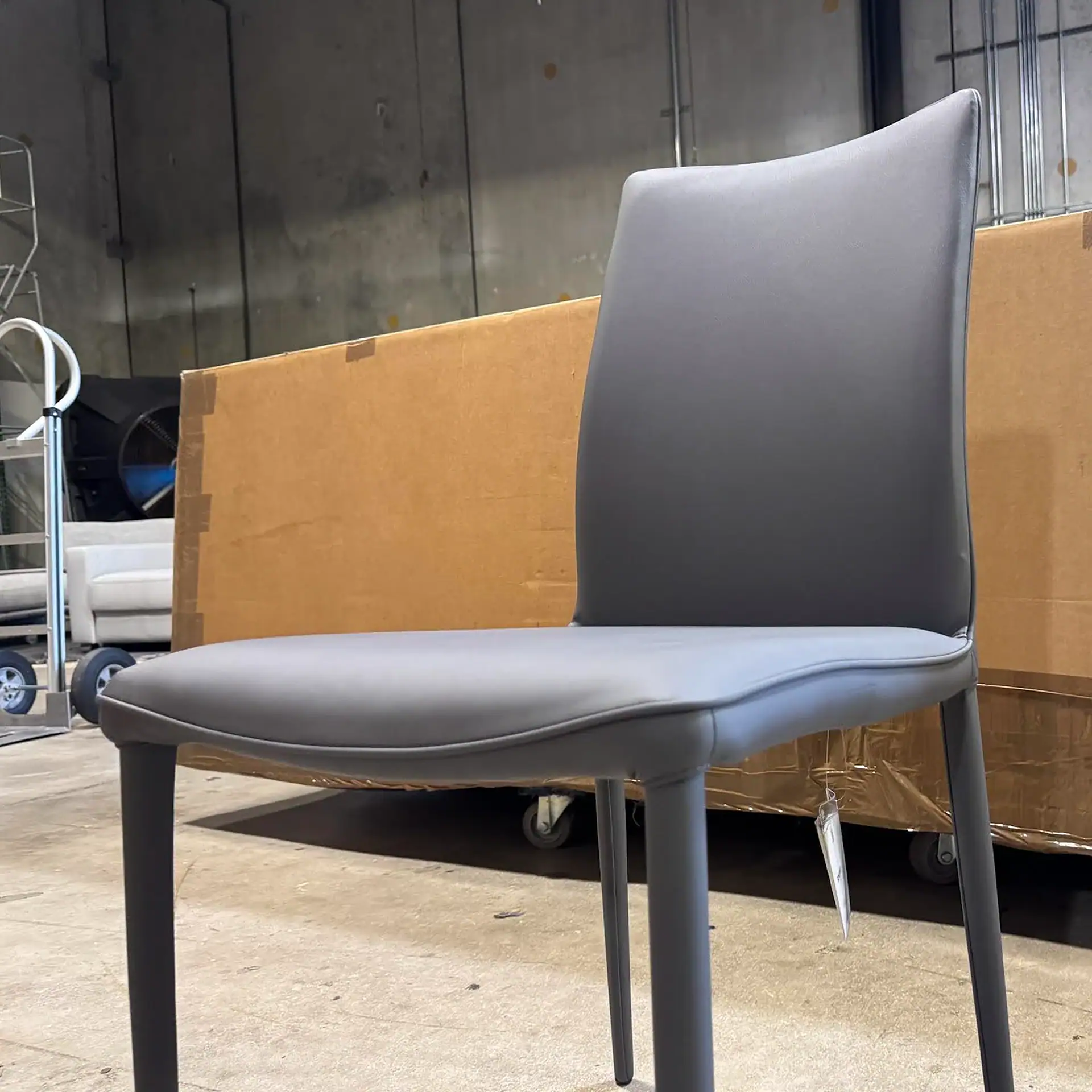Bontempi Shefi Flex dining chair with grey upholstery in a warehouse setting.