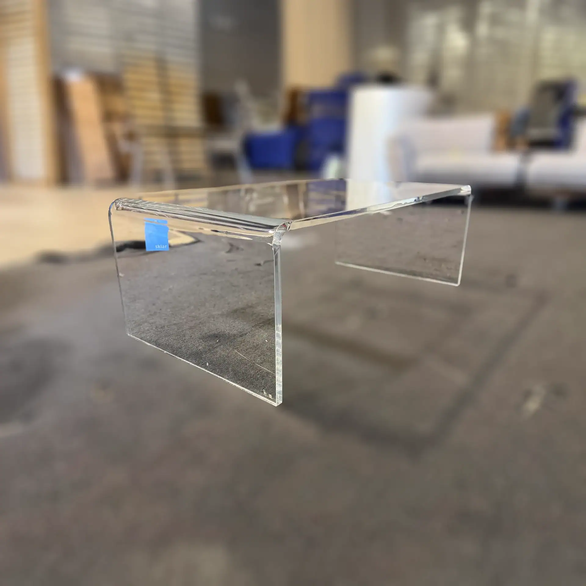 Sklar Furnishings acrylic coffee table in showroom setting.