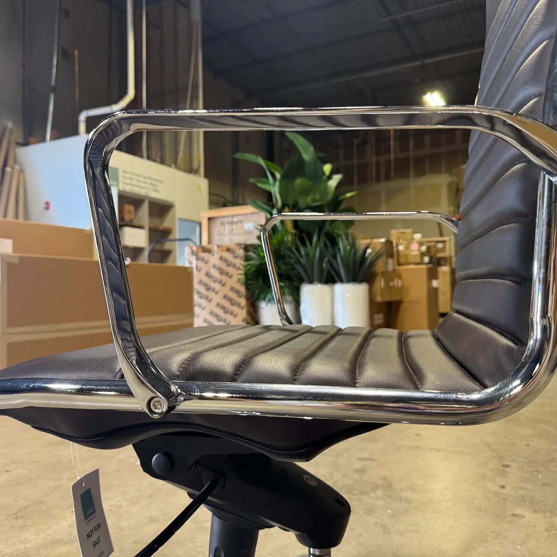 Office chair with chrome frame and black cushioned seat and backrest.
