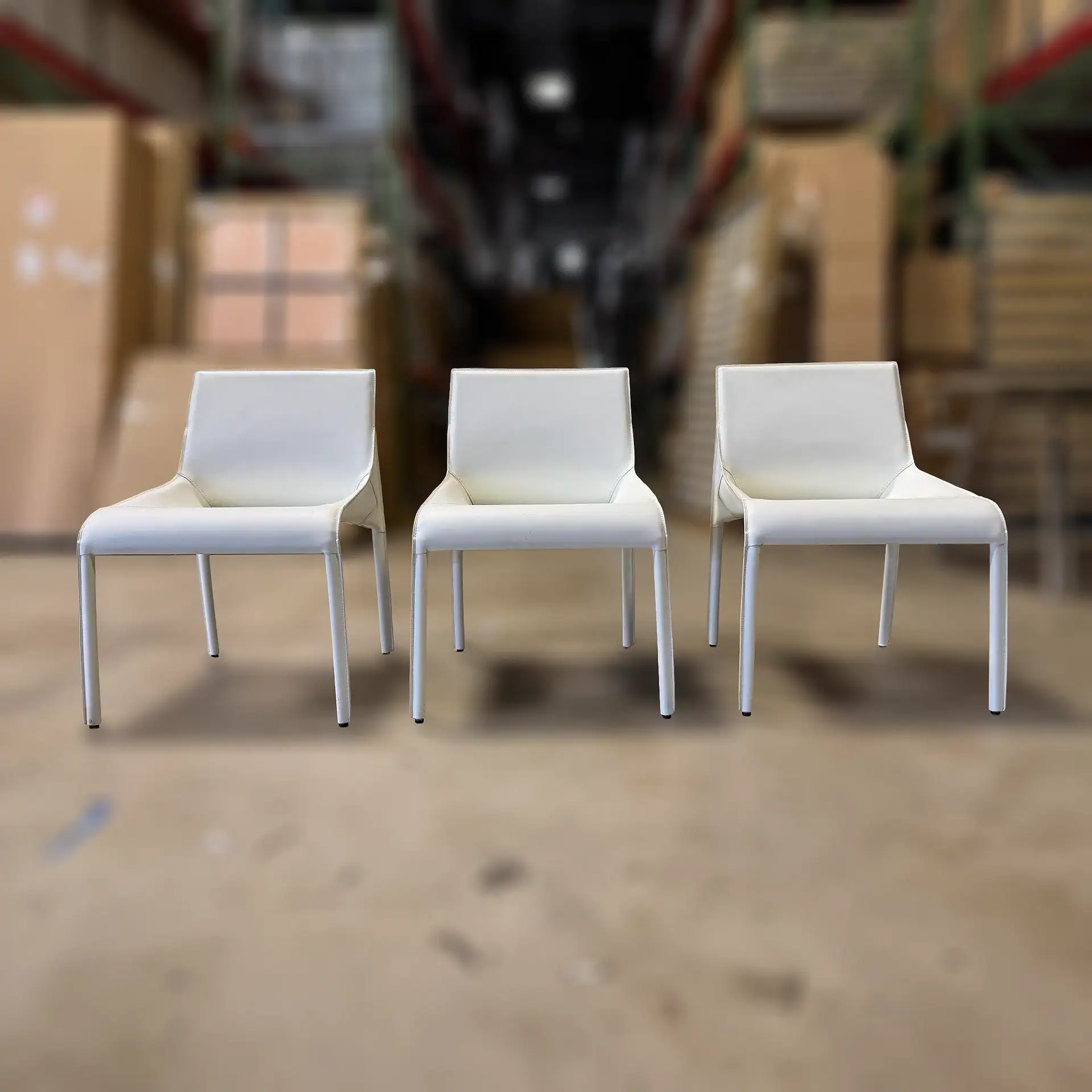 Three Nuevo Colter dining chairs in a warehouse setting.