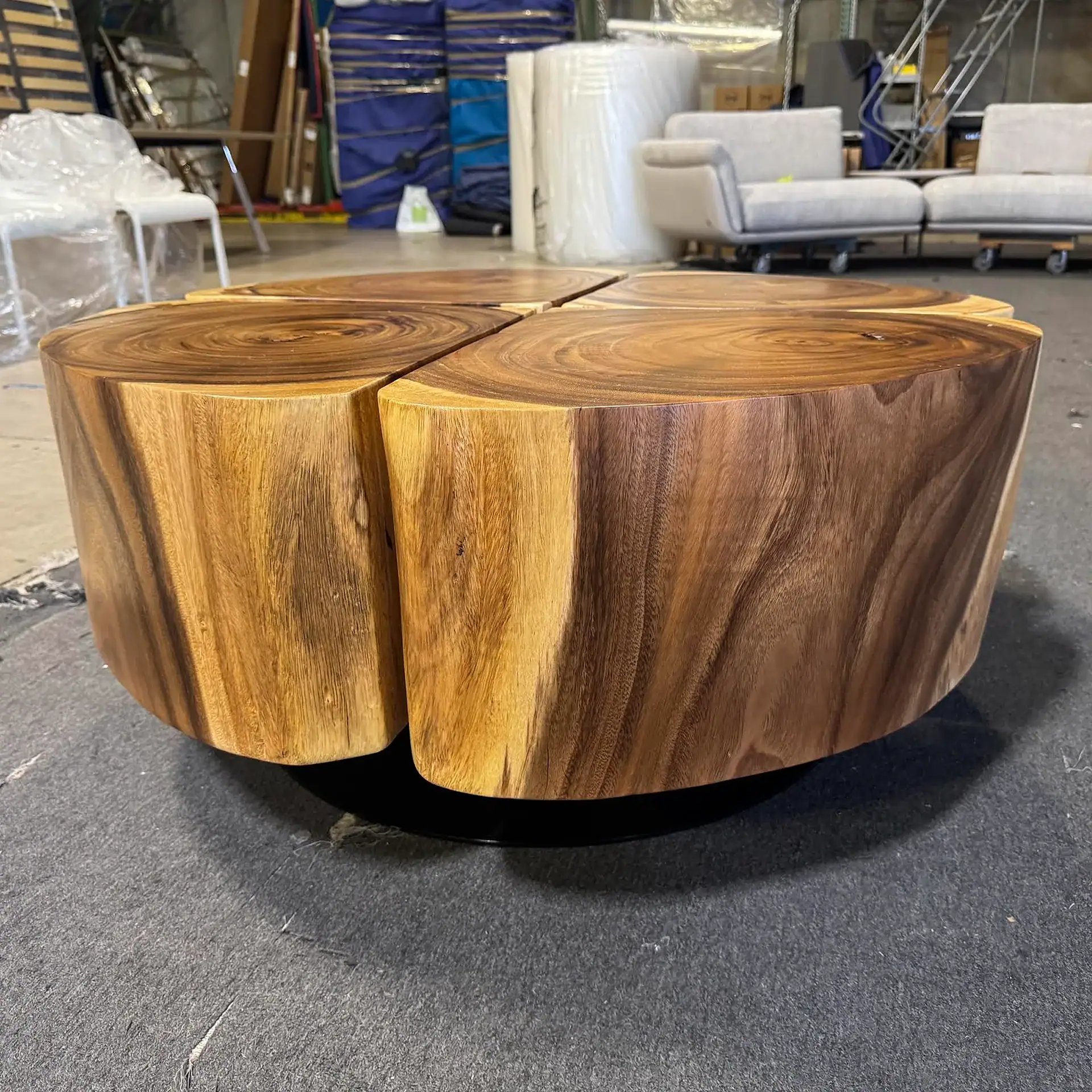 Sklar Furnishings wooden coffee table with a natural finish in a warehouse setting.
