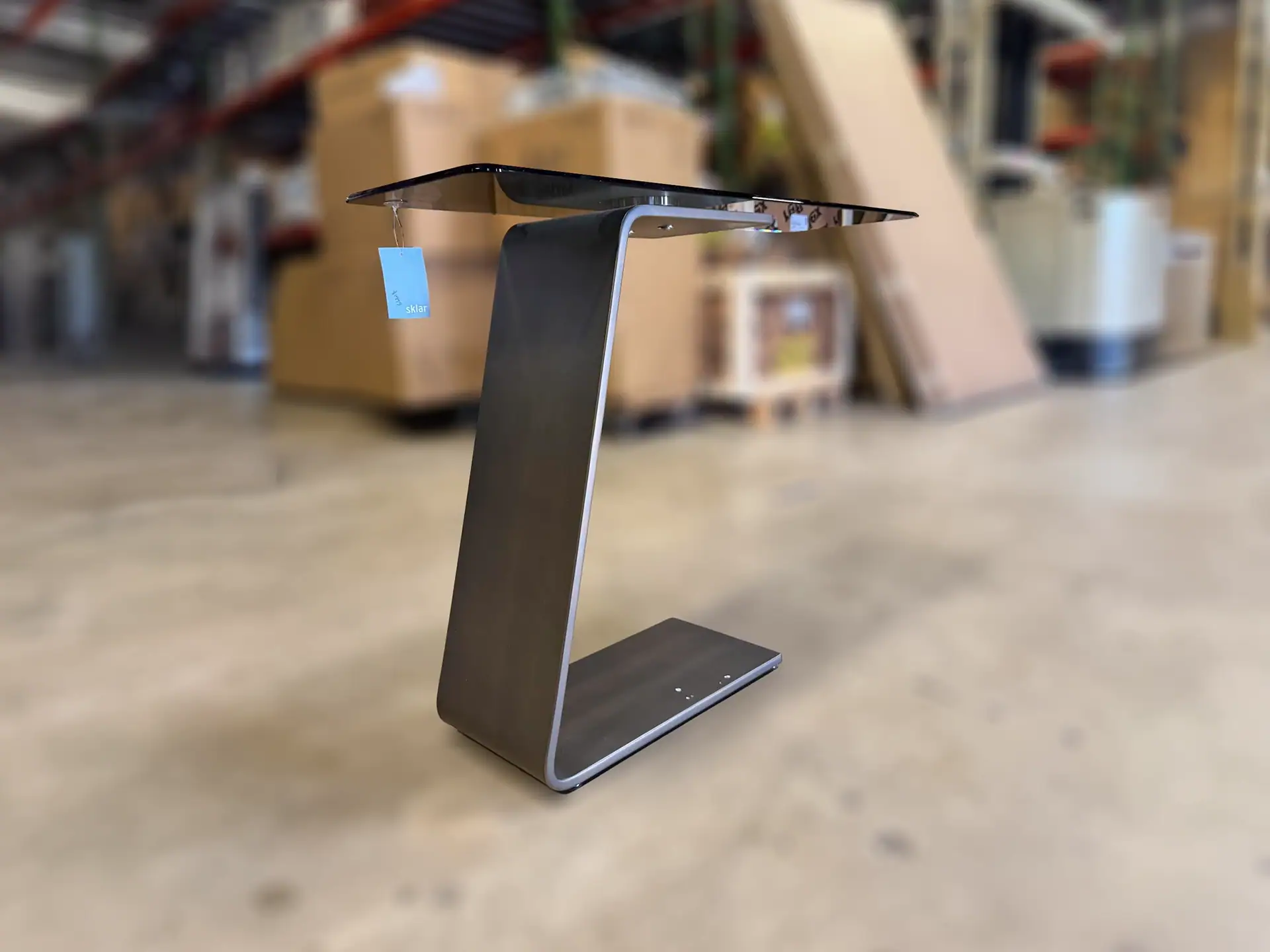 Reflex OH console table with black finish in a warehouse setting.
