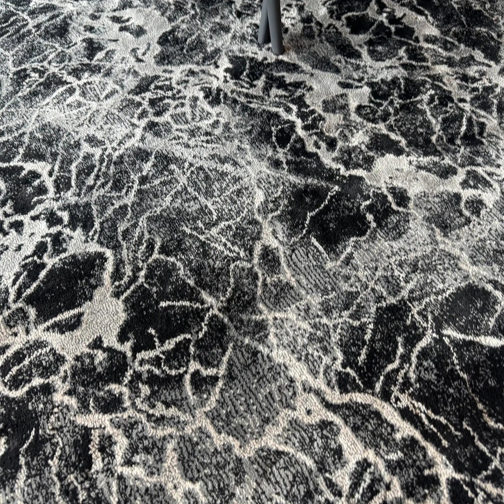 Stanton Zeus round rug with black and white abstract pattern.