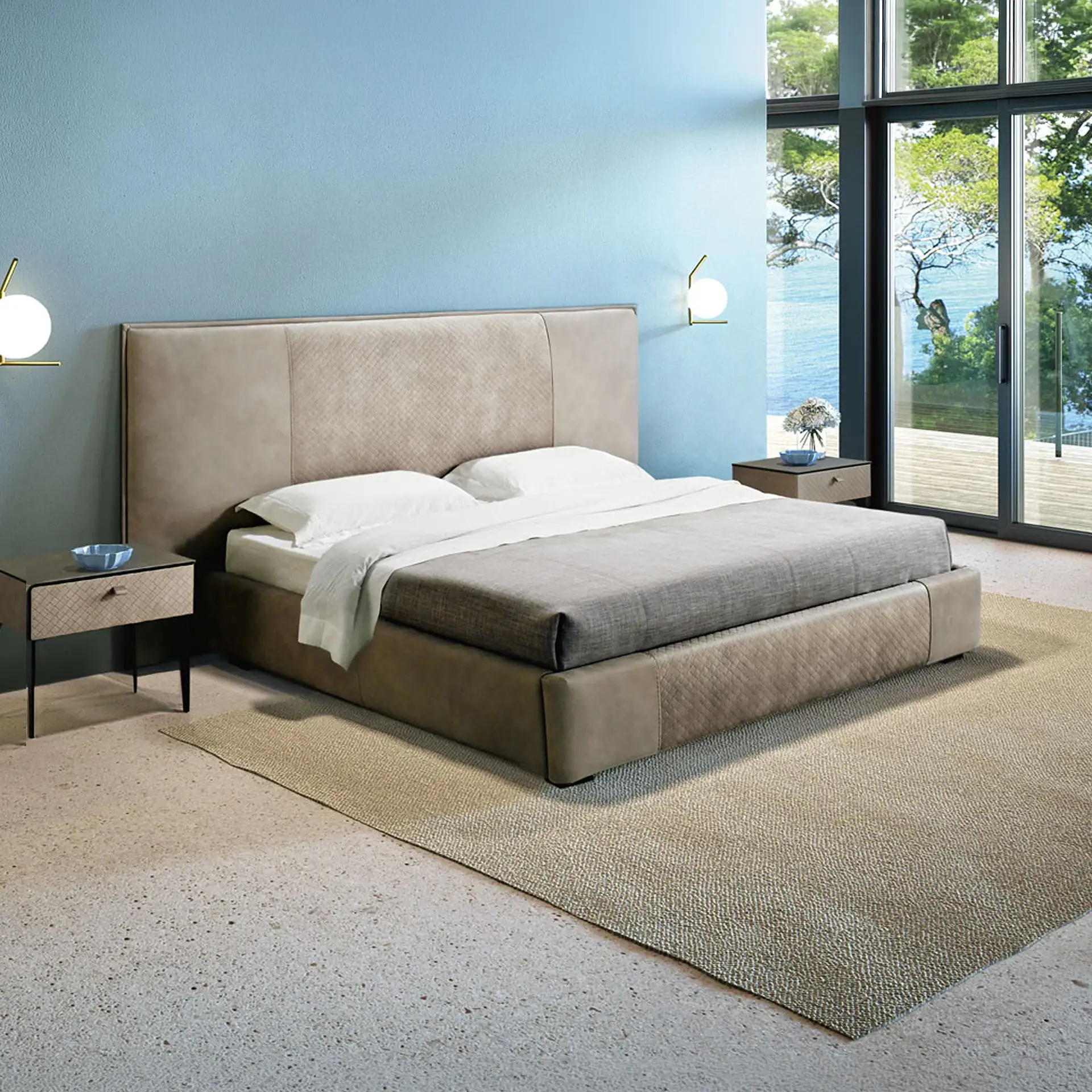 A modern bedroom with a beige upholstered bed, two nightstands, and a large window offering a view of a blue body of water and green trees.