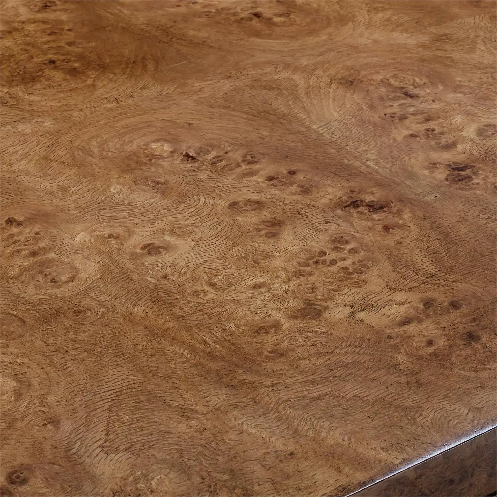 Close-up of a polished burl wood surface with swirling grain patterns and small knots.