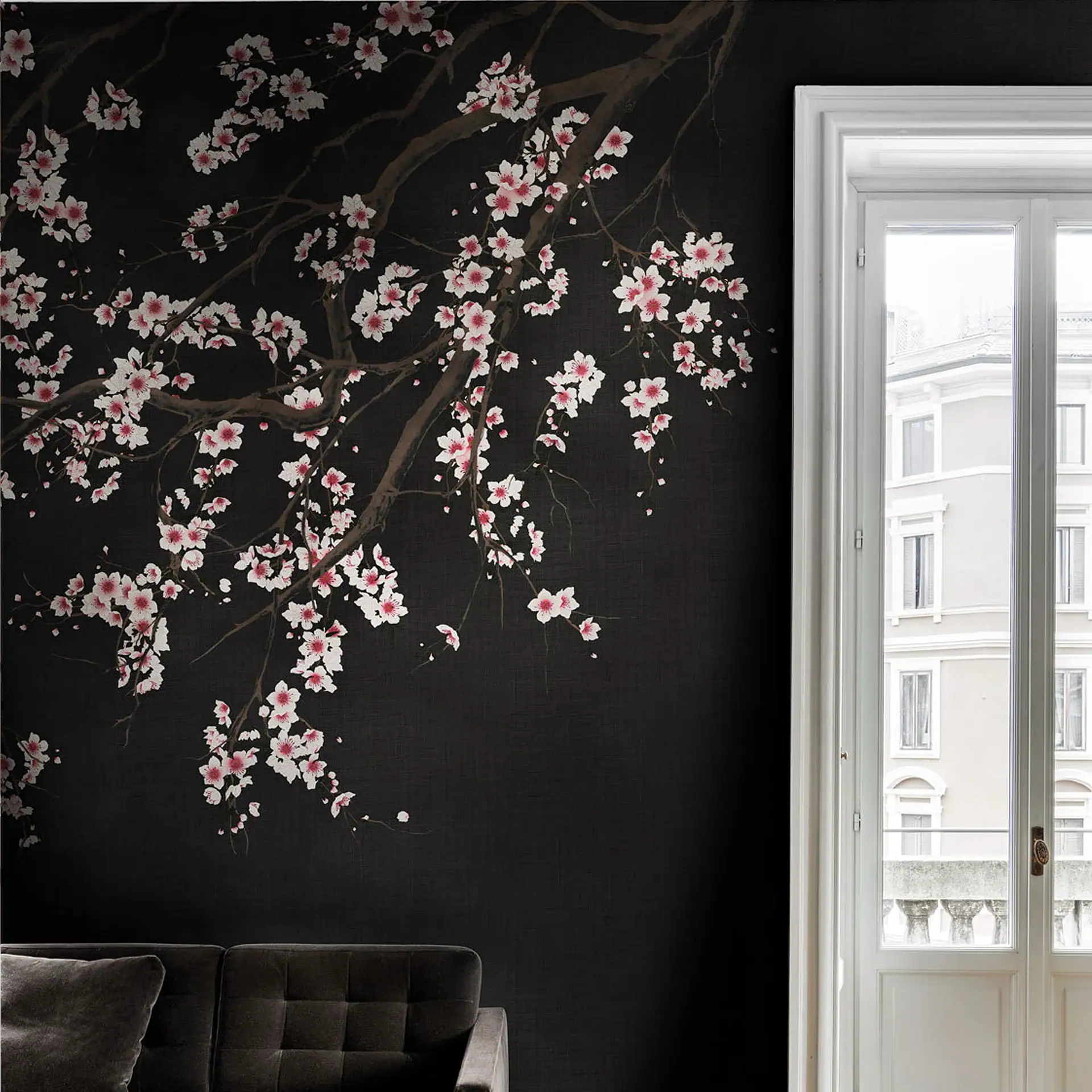 A dark wall with a cherry blossom mural featuring white and pink flowers. A white French door is on the right, and a dark sofa is in the lower left.