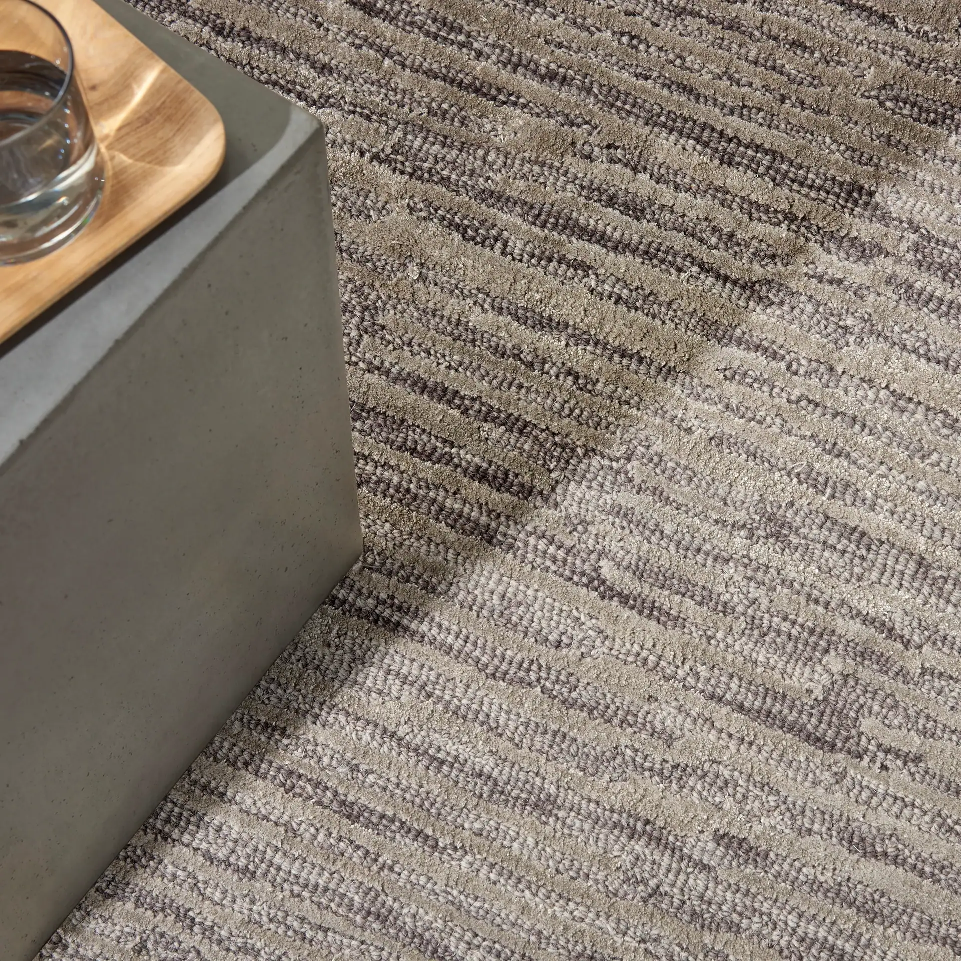 Close-up of textured carpet with neutral beige and brown tones.