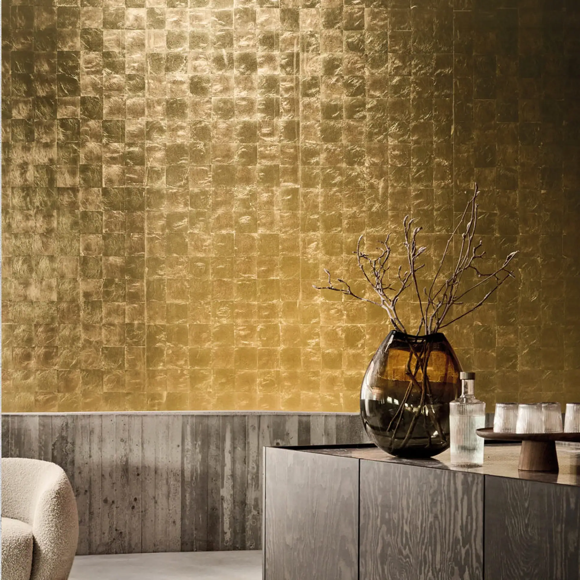 Gold metallic leaf wallpaper on wall with decor in room.