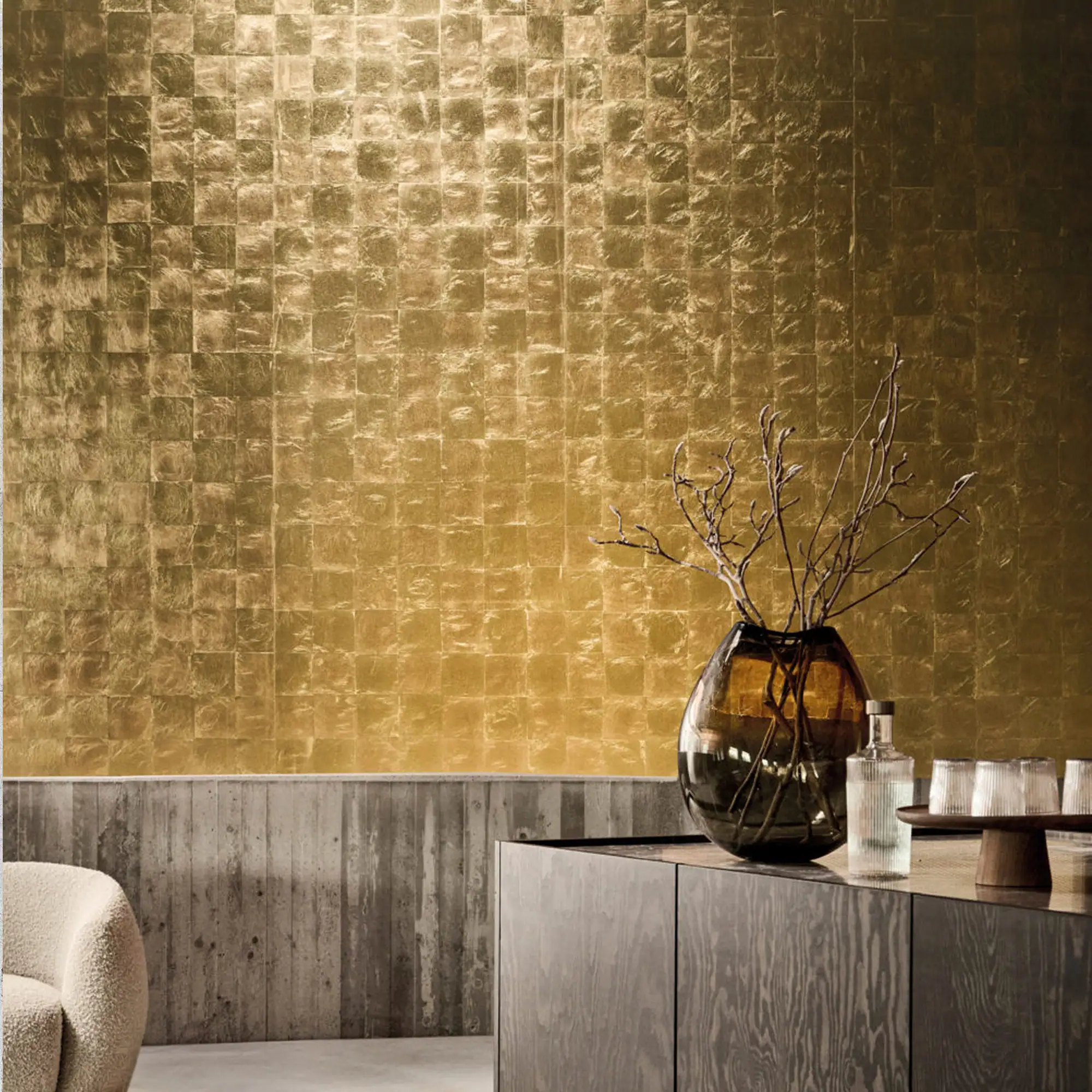 Gold metallic leaf wallpaper on wall with decor in room.