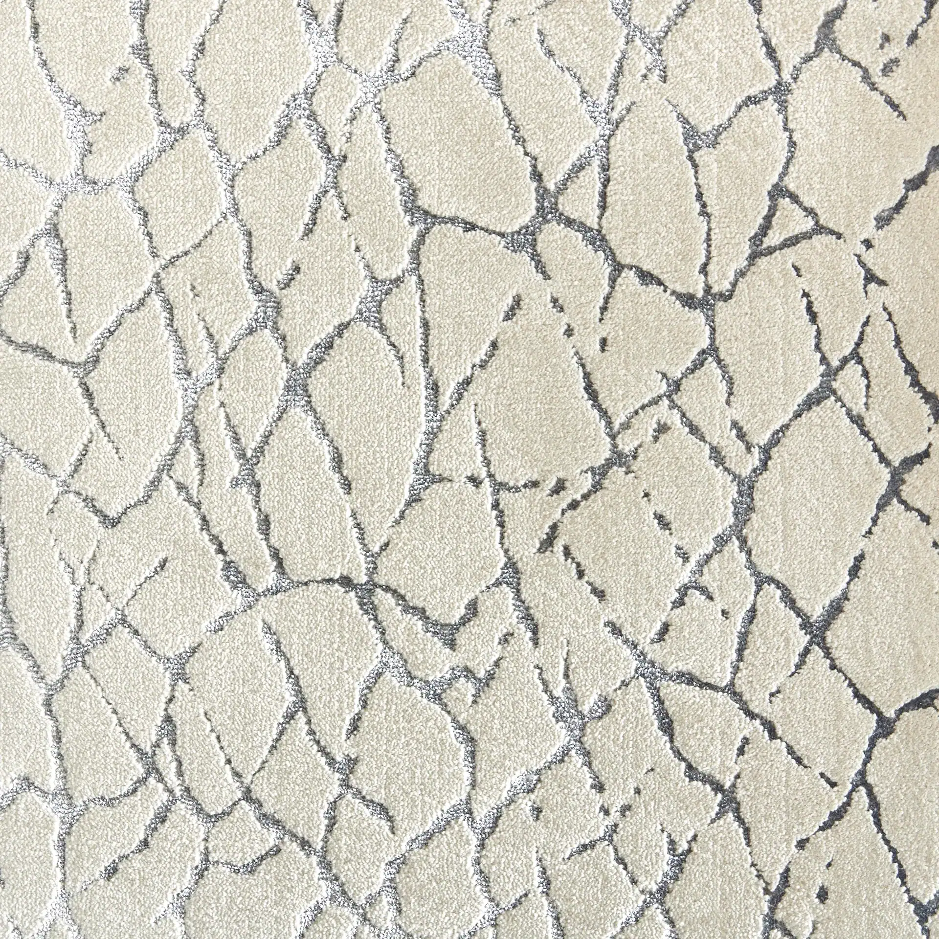 Close-up of a cream-colored carpet with a dark gray abstract crackle pattern.