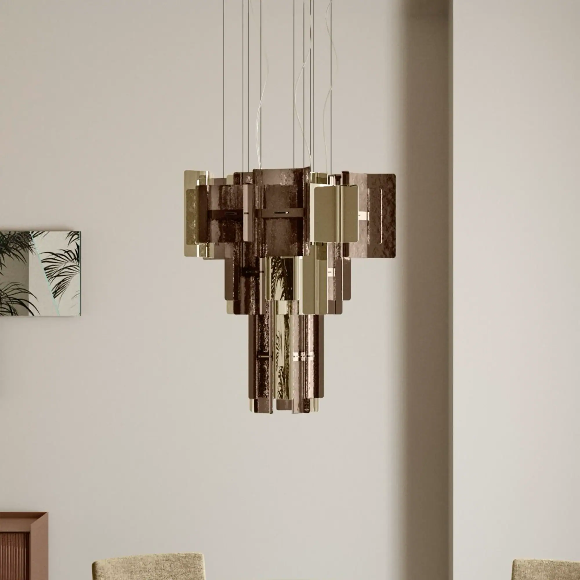 A modern tiered chandelier composed of rectangular panels of textured amber glass and reflective gold metal, suspended against a light background.