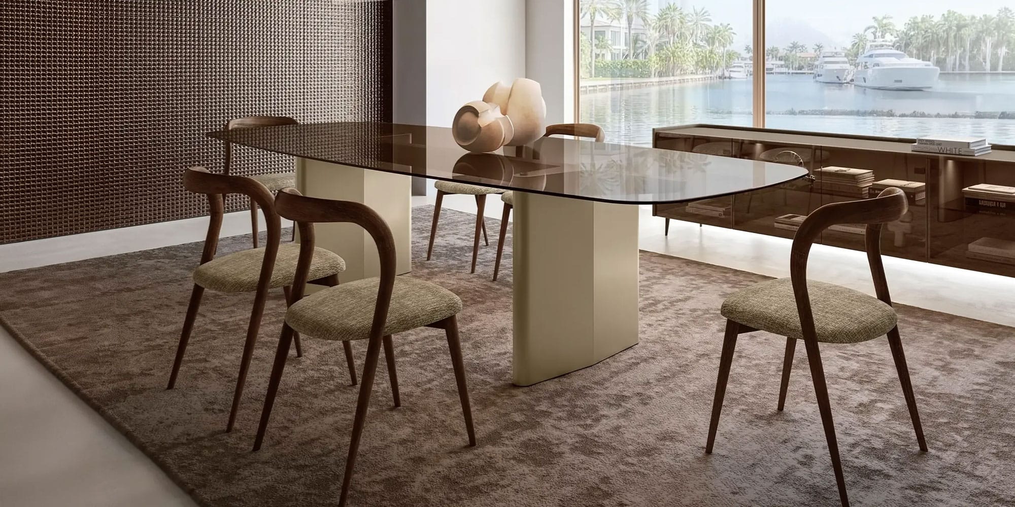 tonelli-nuvolari-dining-table-blog-hero A modern dining room with a smoked glass table, six wooden chairs, and a view of a waterfront with yachts and palm trees.