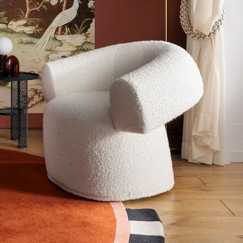 Sklar Furnishings white textured armchair in a cozy room setting.