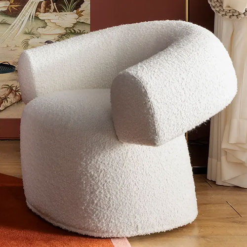 Sklar Furnishings white textured armchair in a cozy room setting.