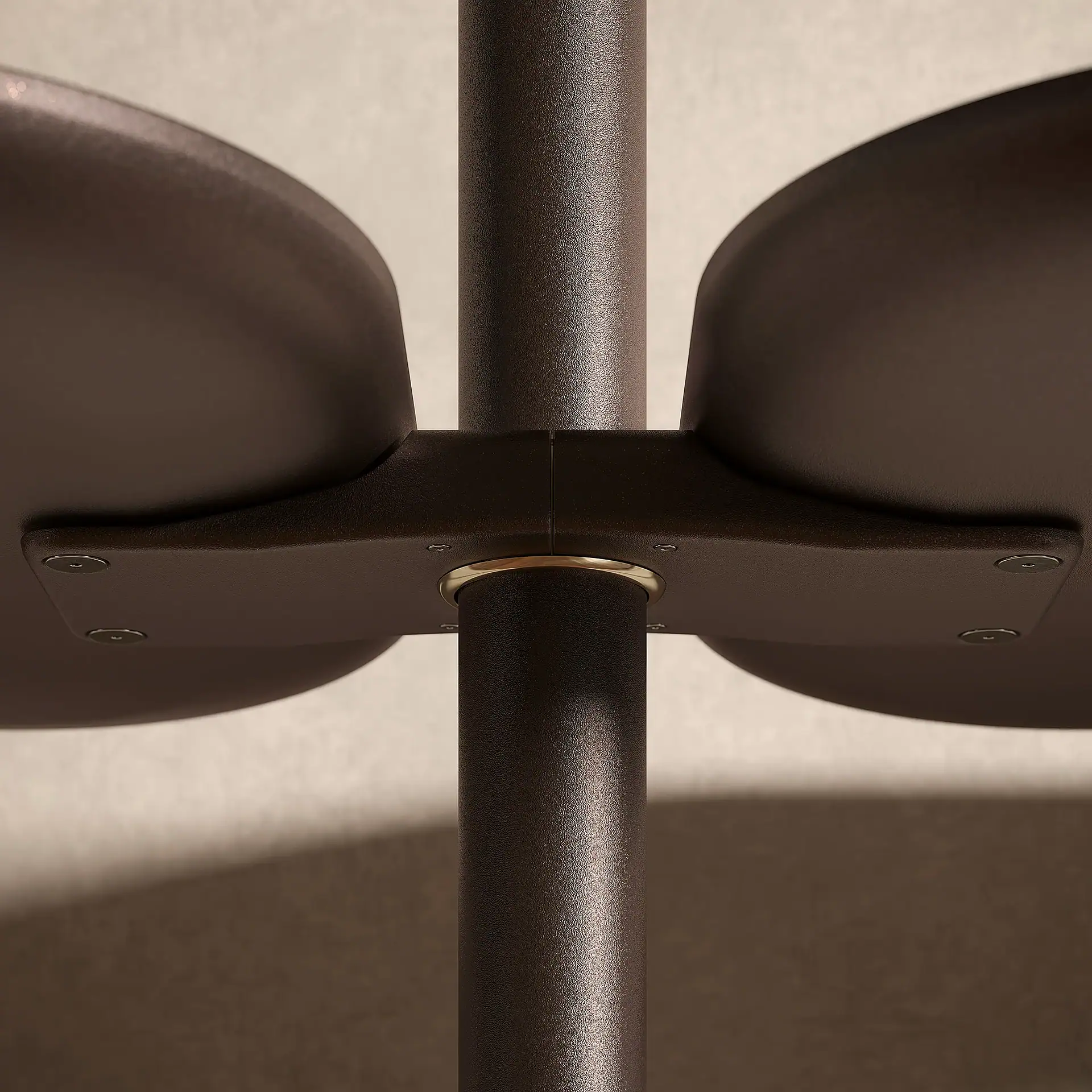 Close-up of a dark brown textured metal pole with two curved platforms attached by a bracket, featuring a golden ring.