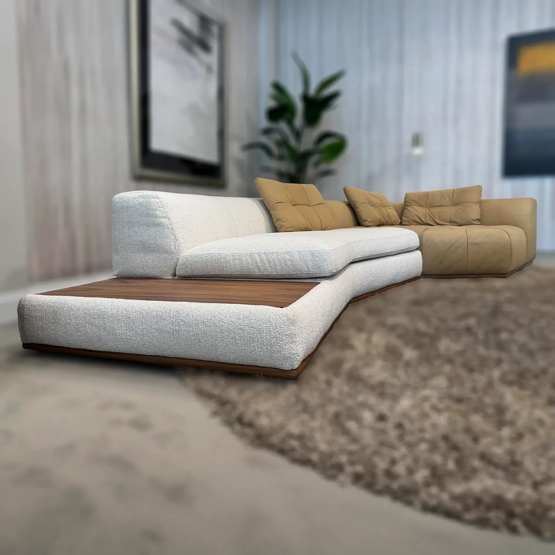 An L-shaped sectional sofa with a white textured fabric section and a tan leather section, featuring an integrated wooden armrest, placed on a shaggy brown rug in a modern living room.