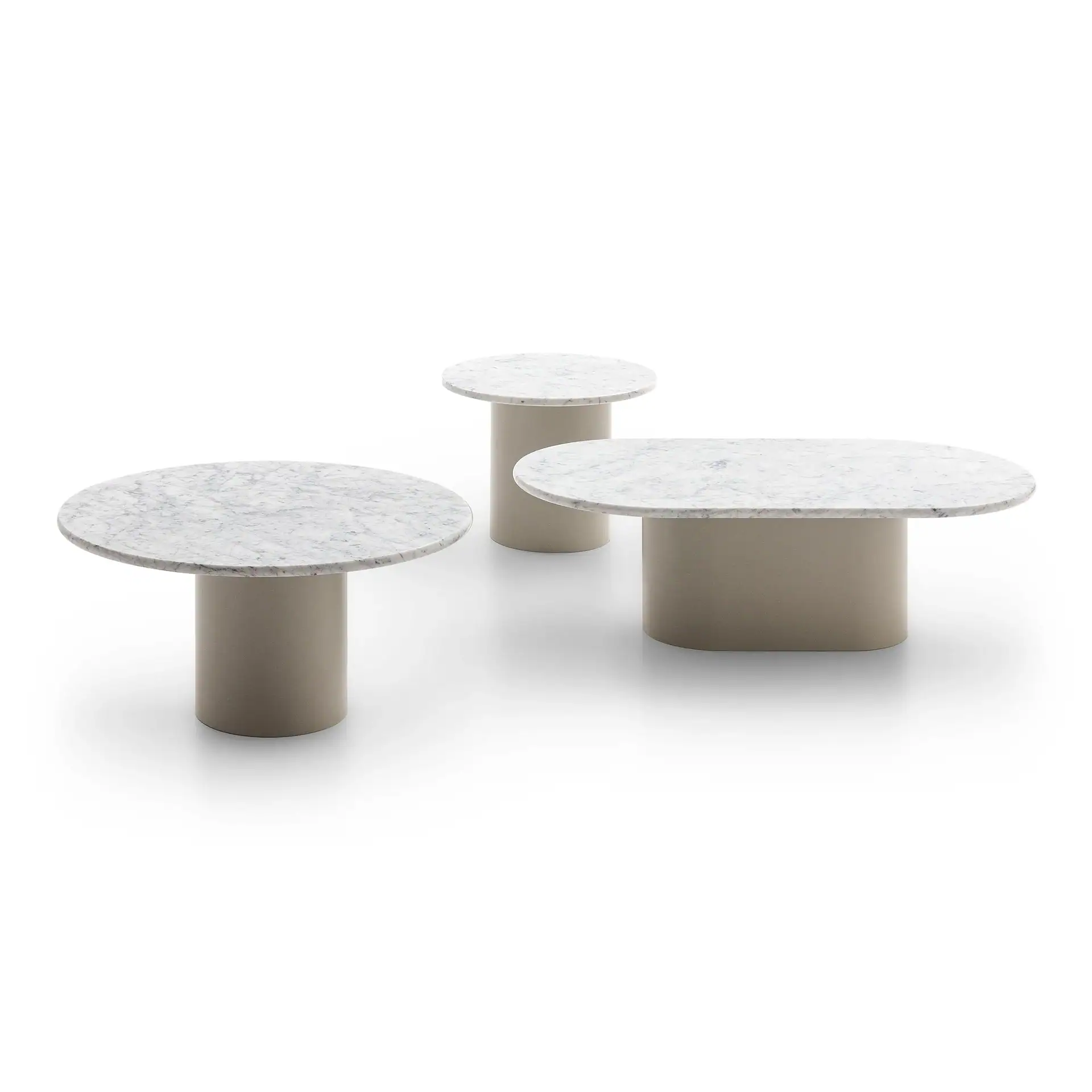 Three tables with white marble tops and solid beige bases on a white background. Two are round, one is oval.