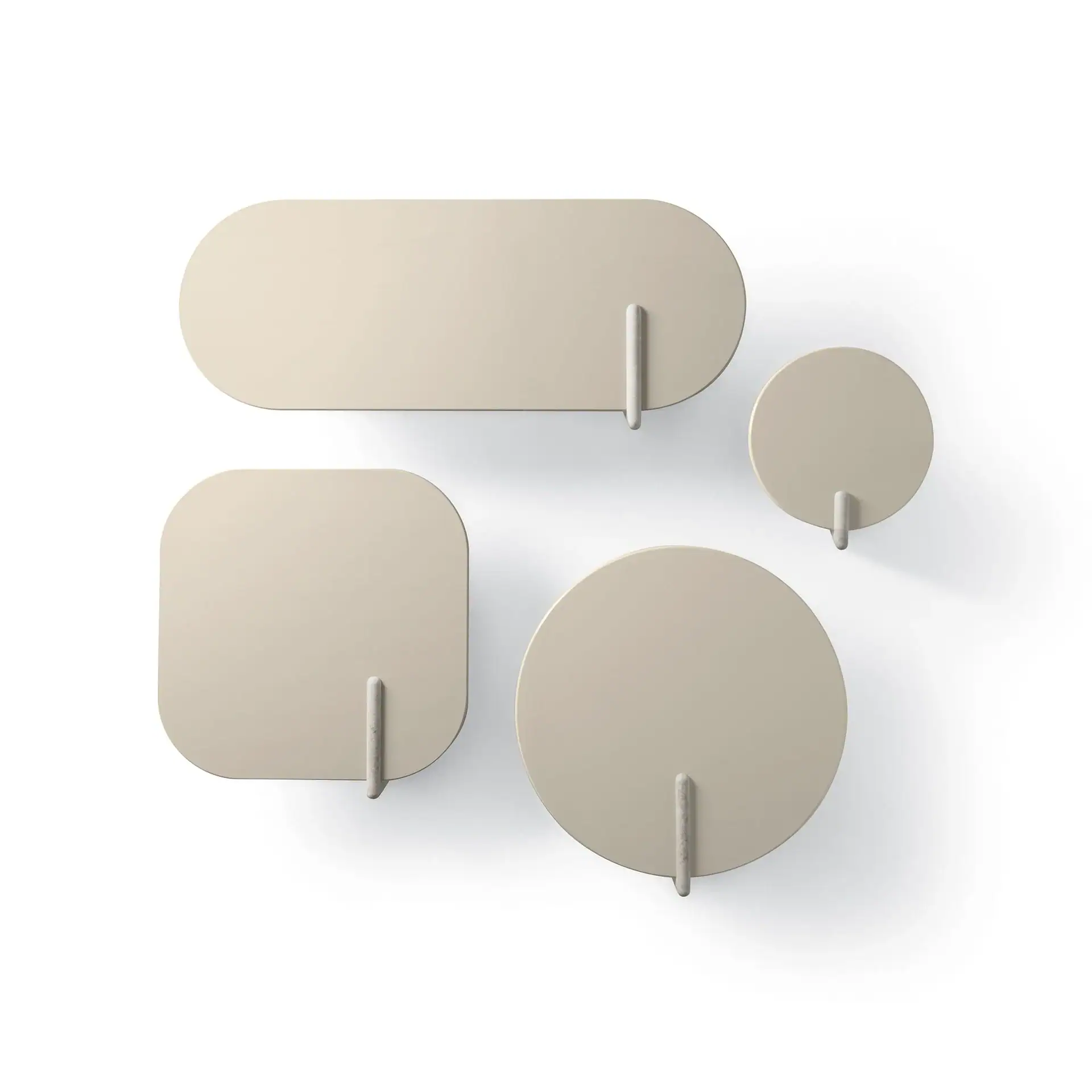 Four beige wall-mounted shelves or hooks in different shapes: an elongated rectangle, a square, a large circle, and a small circle, each with a downward-protruding rod, on a white background.